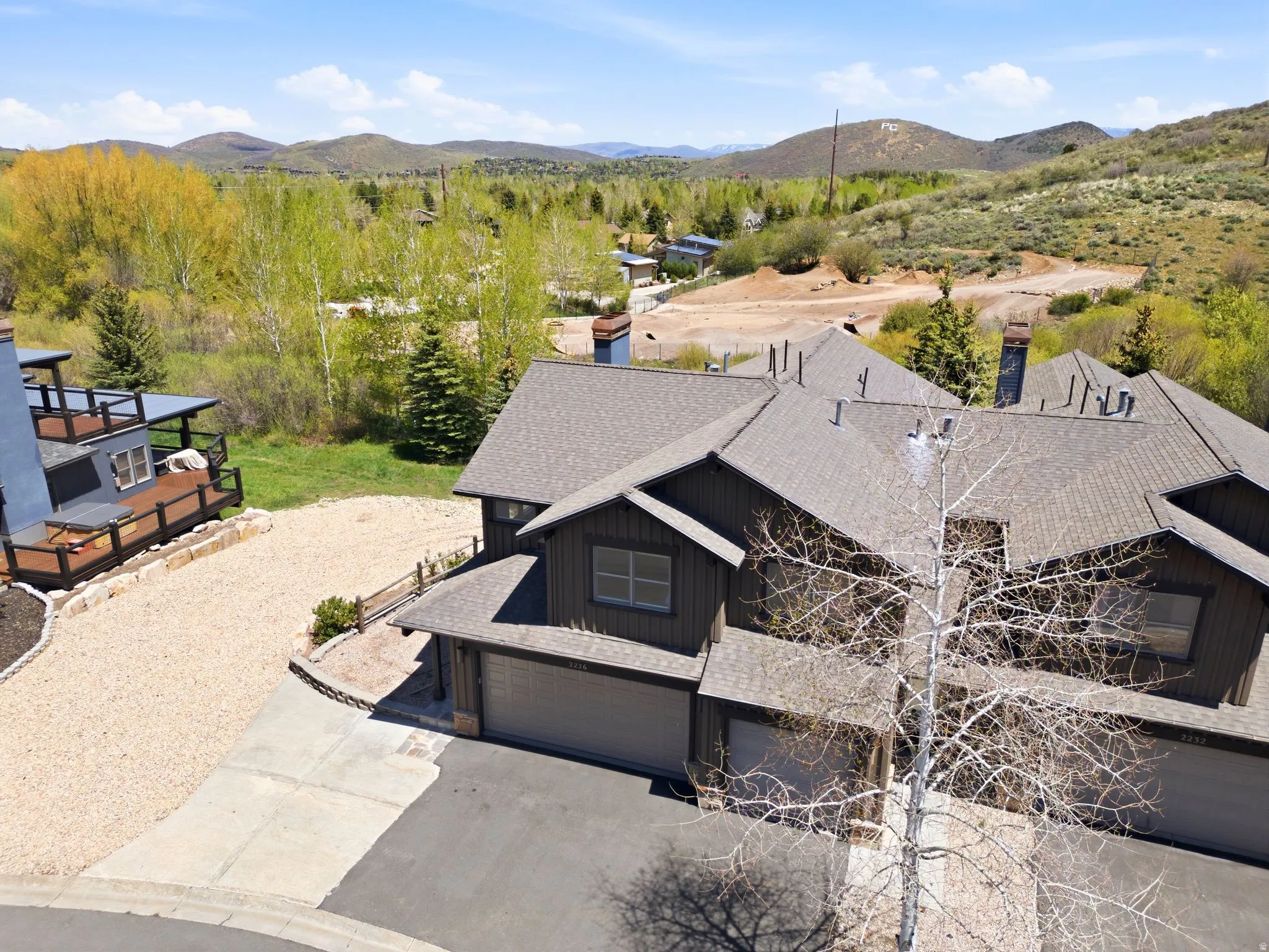 Multi-unit property featuring dark siding and gray shingle roofing