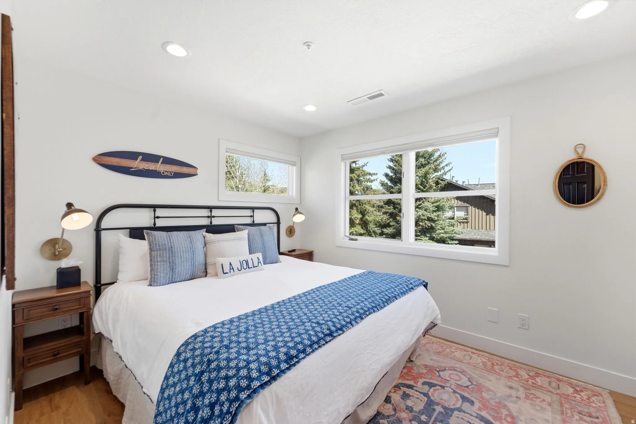 Bright room featuring white walls, recessed lighting, and wood-finish flooring