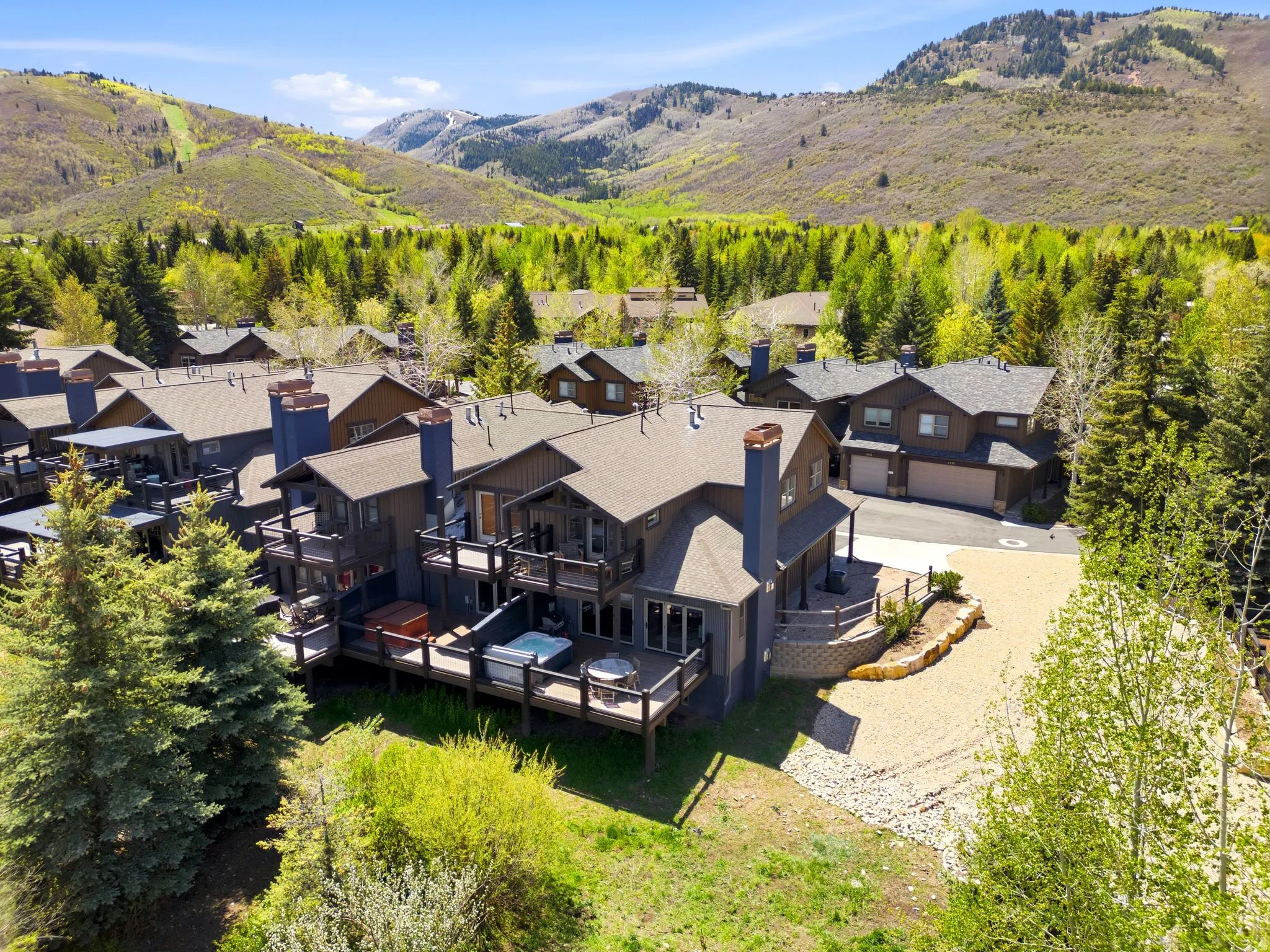 Mountain-style residence featuring multiple balconies, a hot tub, and an expansive deck