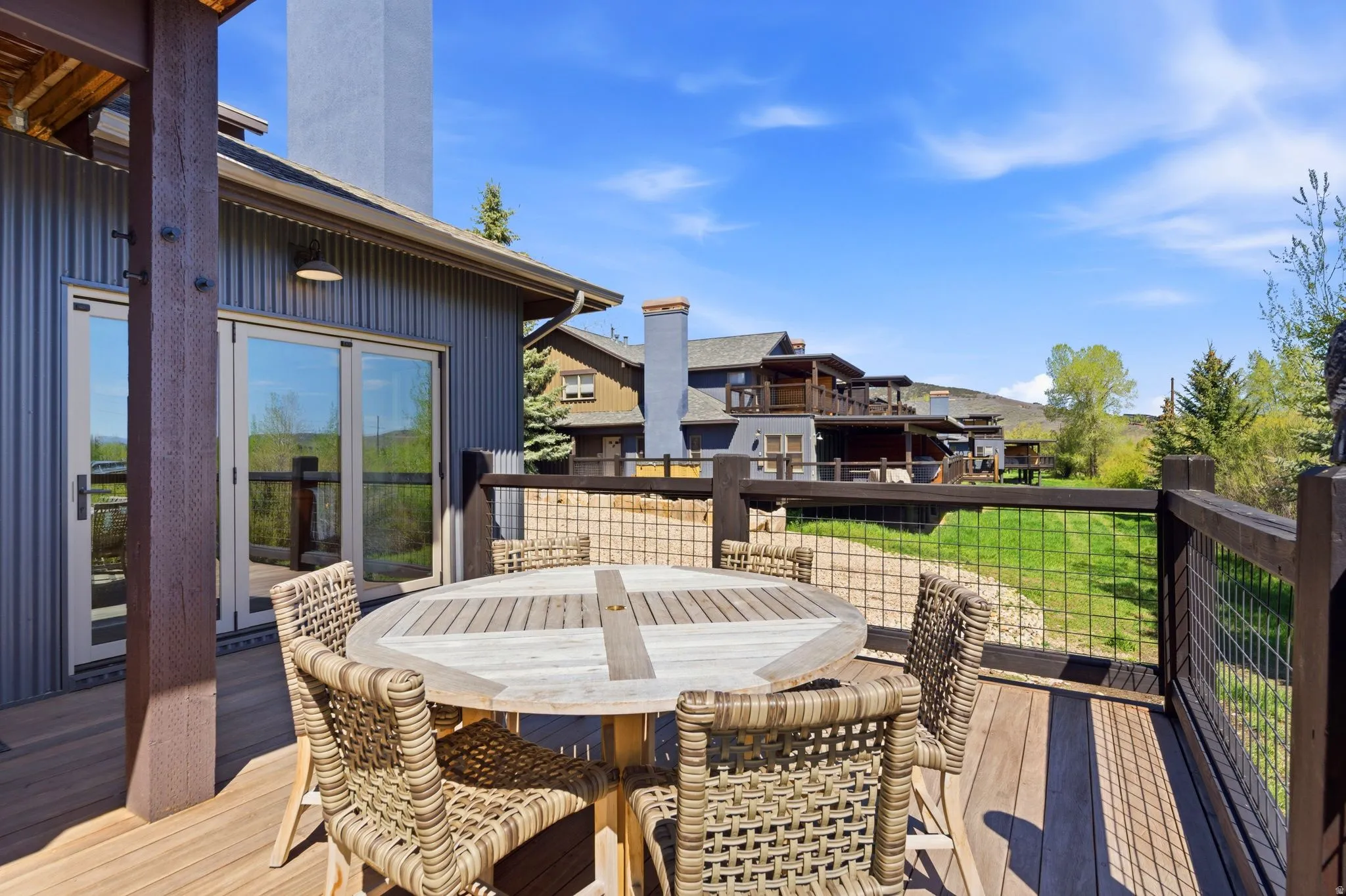 Spacious outdoor deck featuring wood-finish flooring and a rustic wood railing with wire mesh infill