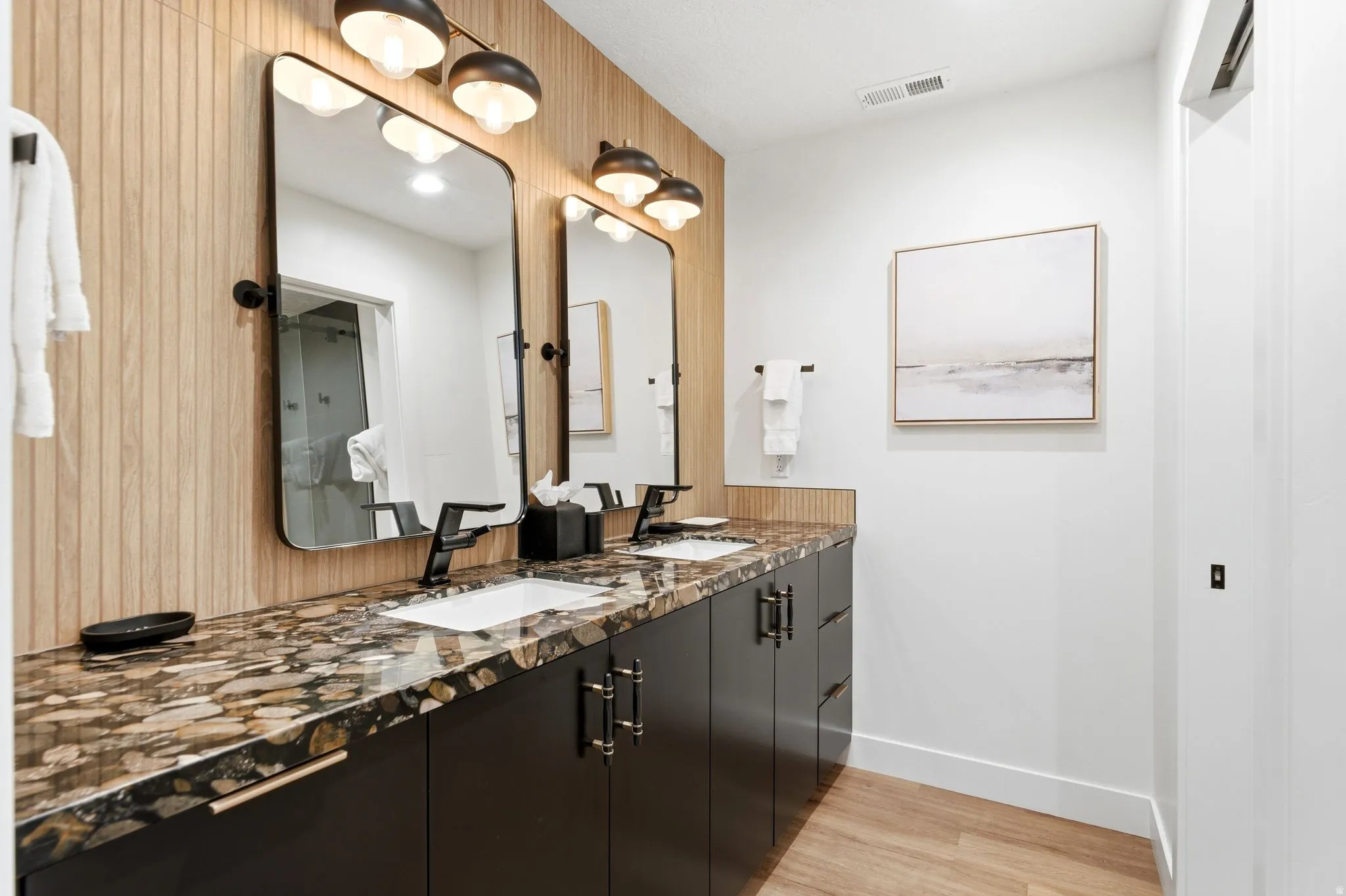 Double vanity with stone countertop, black cabinetry, and matte black fixtures