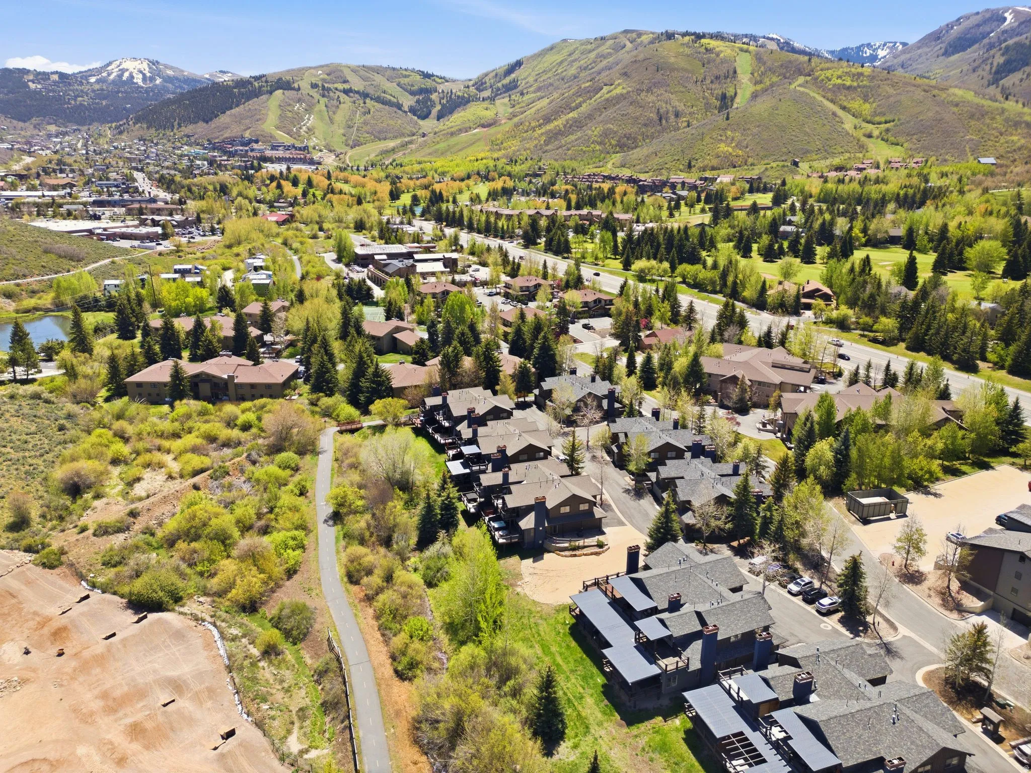Expansive aerial perspective showcasing a mountainous terrain with lush green hillsides and scattered residential developments