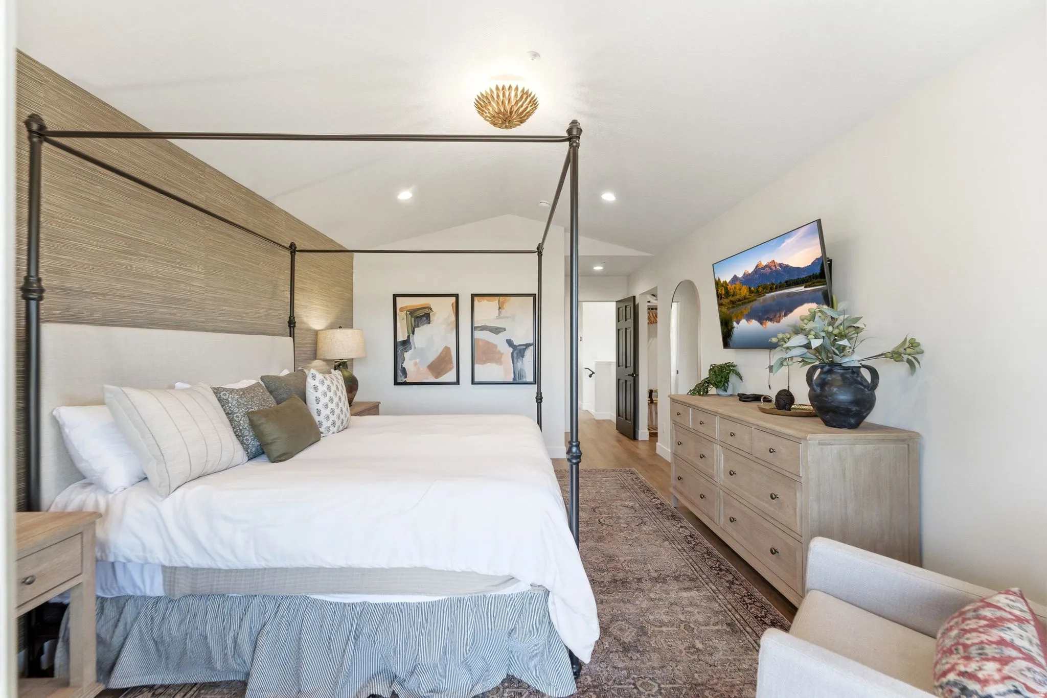 Vaulted ceiling bedroom featuring wood-finish flooring, recessed lighting, and a textured accent wall