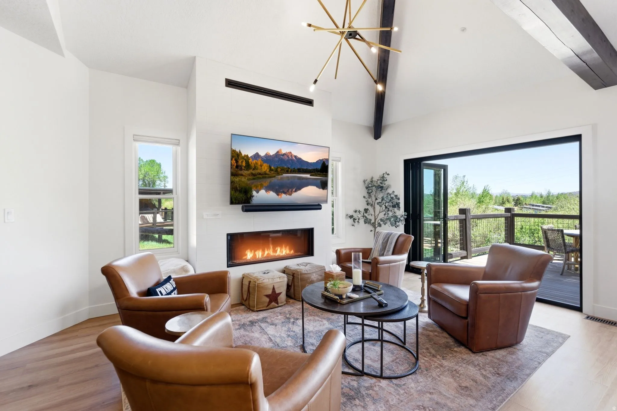 Vaulted ceilings with exposed beams complement the light wood-finish flooring