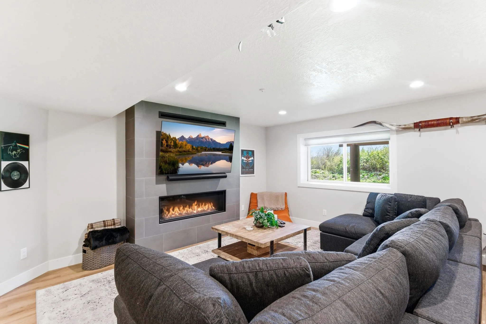 Living area featuring light wood-finish flooring and recessed ceiling lighting