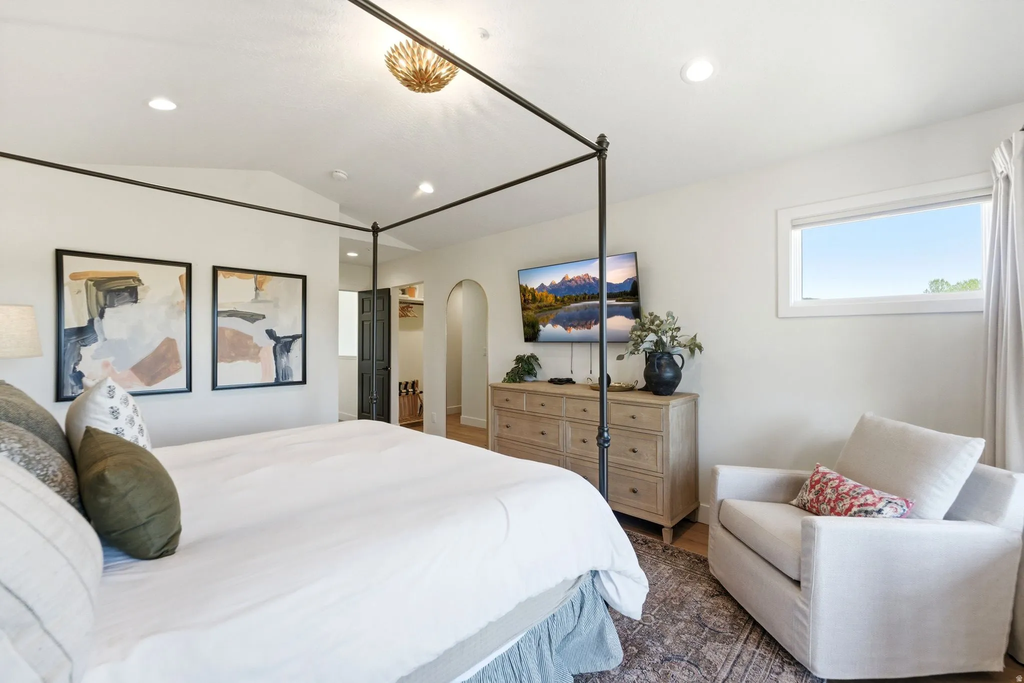 Bright room featuring a four-poster bed frame, recessed lighting, and a decorative ceiling fixture