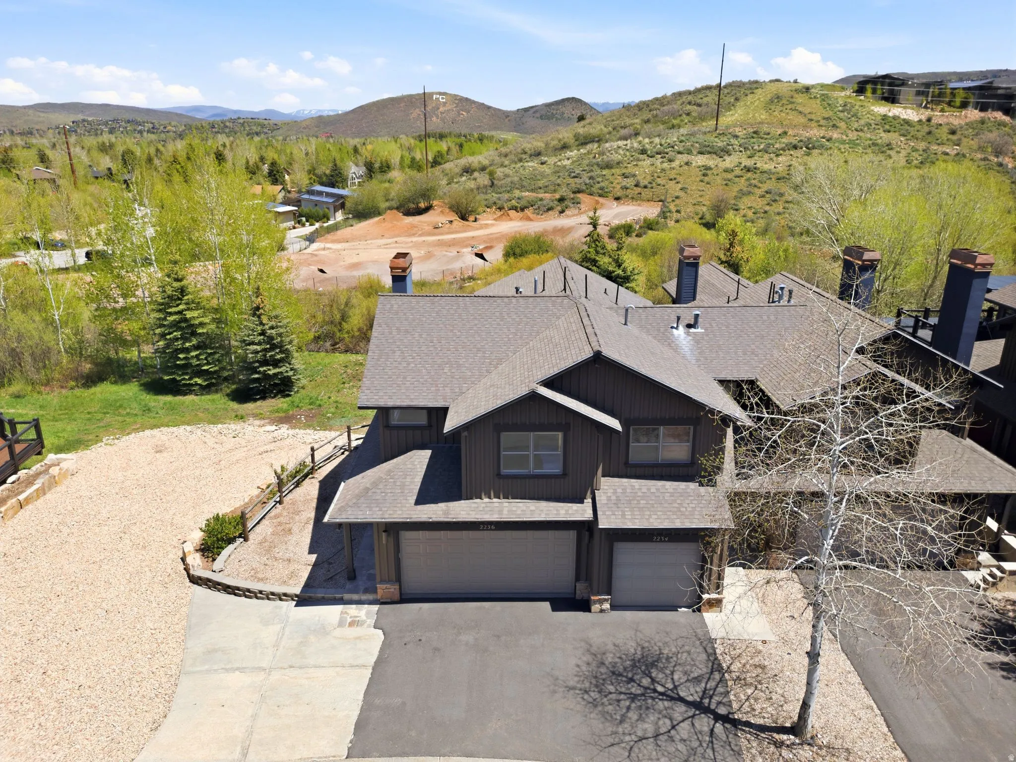 Multi-level property featuring dark siding and a prominent shingled roofline