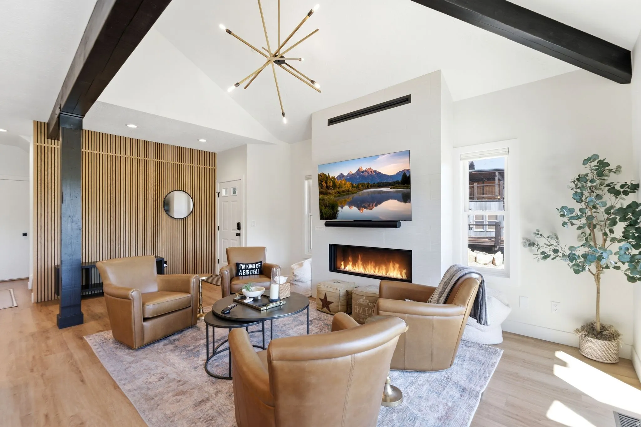 Living area featuring a sleek linear fireplace, wood-finish flooring, and a decorative slatted wood accent wall