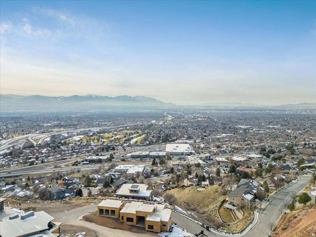 Expansive aerial perspective showcasing a broad urban landscape with distant mountains