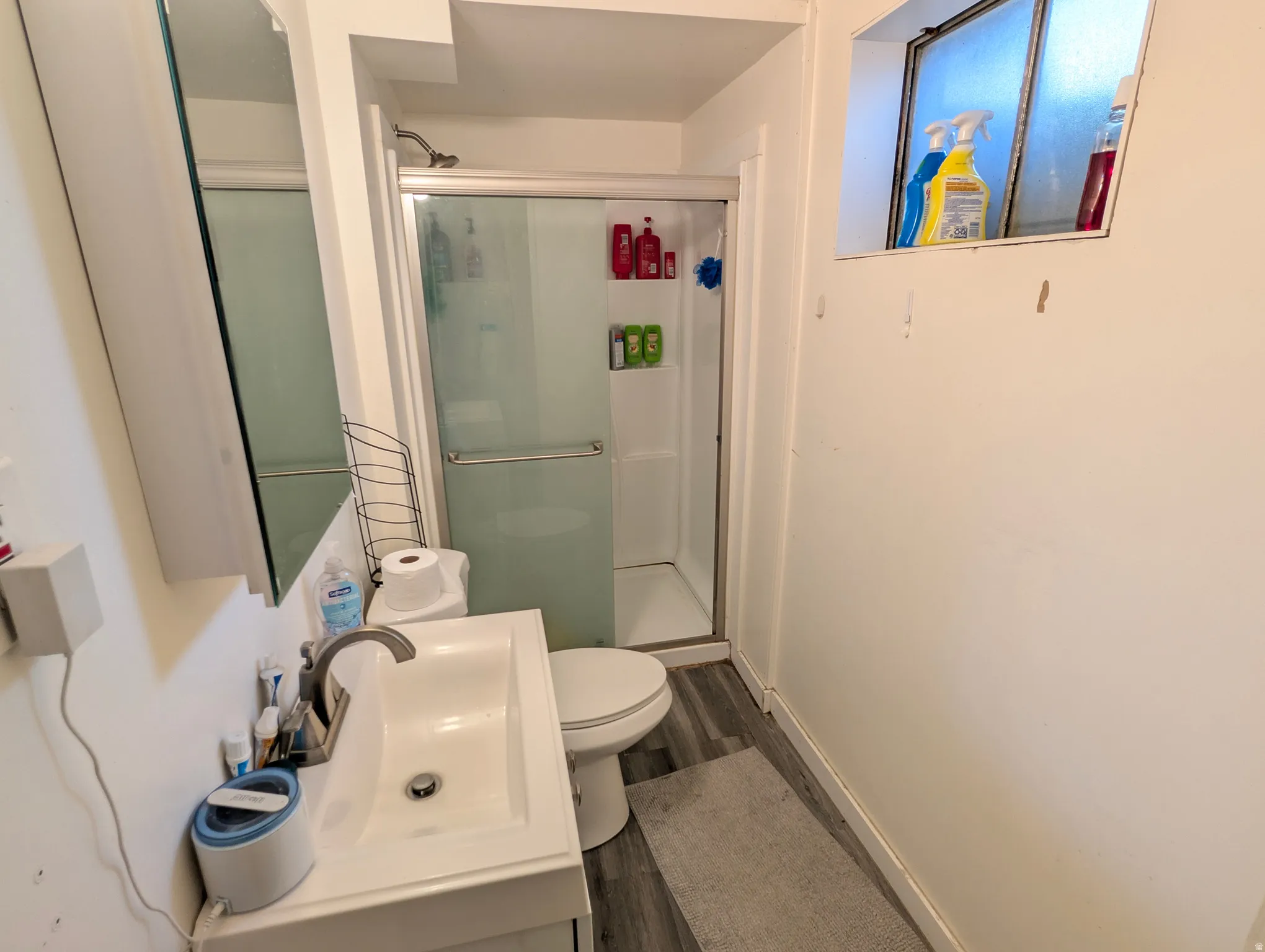 Full bathroom with a stall shower, dark wood-style flooring, and vanity