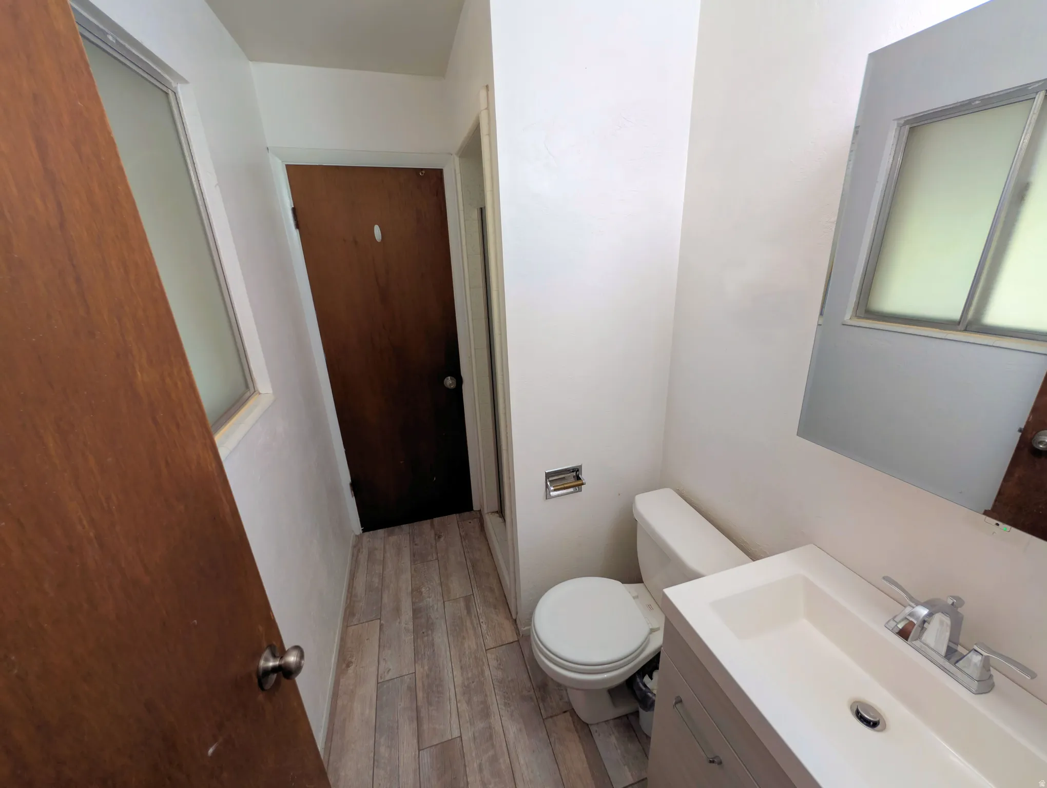 Half bathroom with vanity and light wood-style flooring