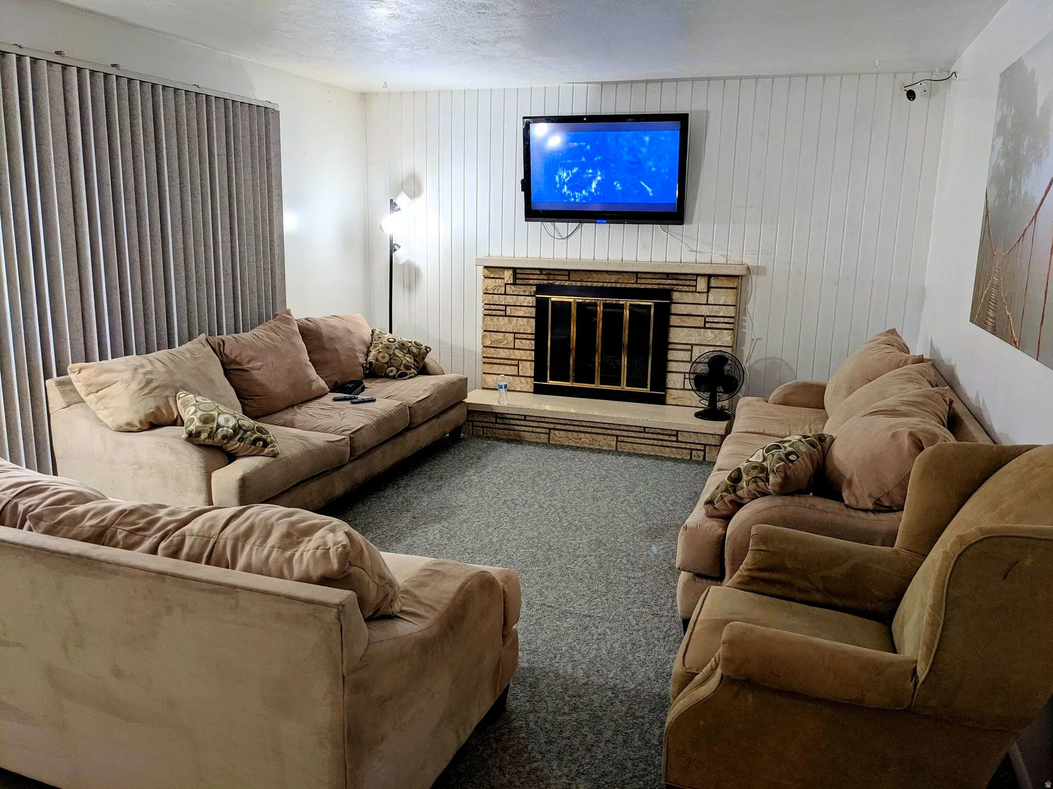 Carpeted living room with a stone fireplace