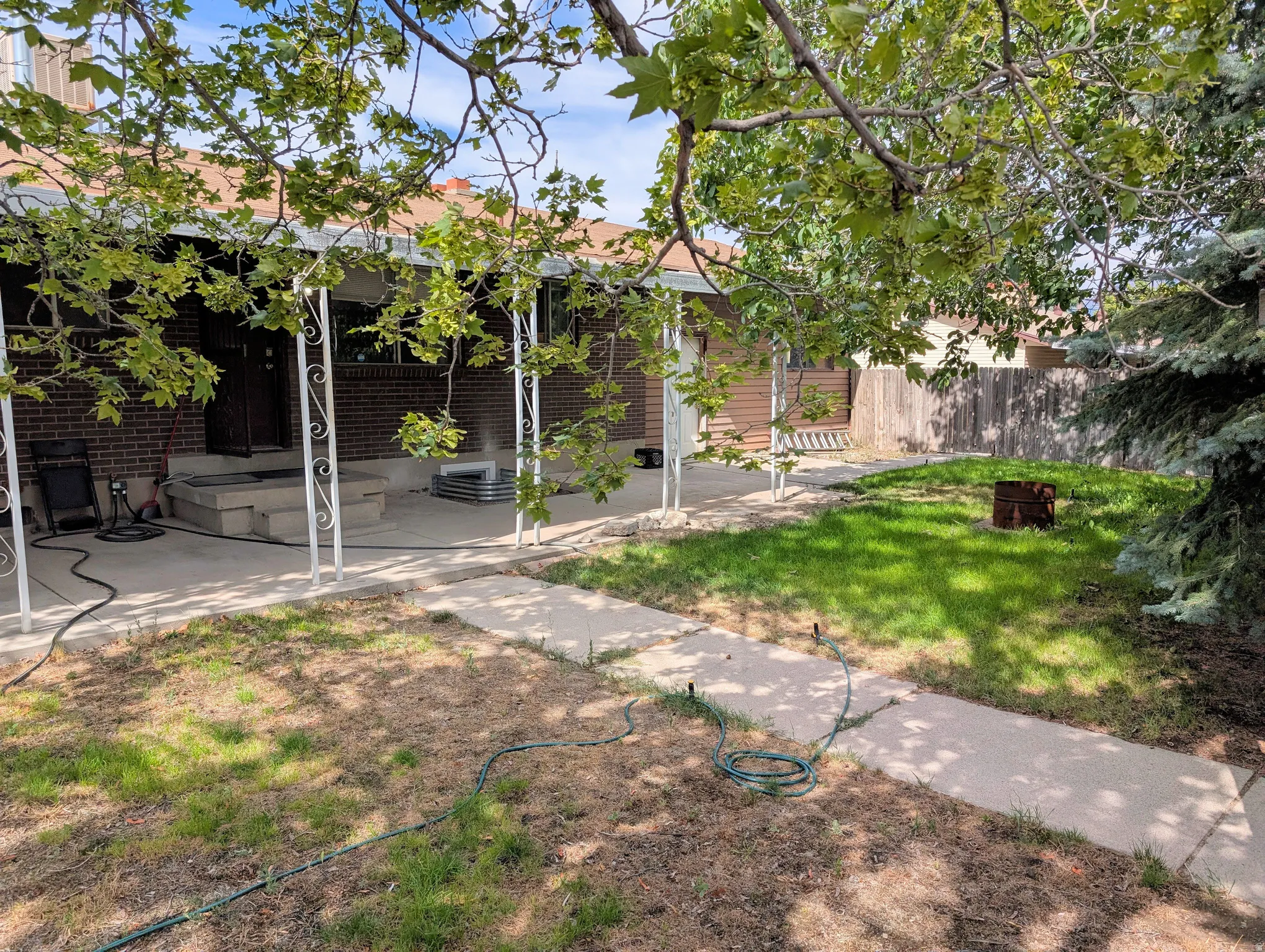 Back of property featuring a patio area, an outdoor fire pit, and brick siding