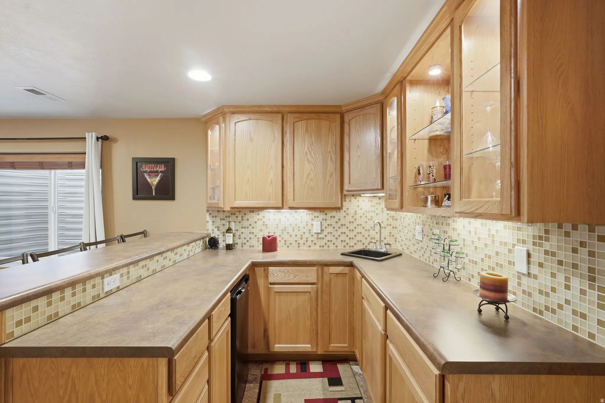 U-shaped wet bar featuring hot and cold water, garbage disposal, and mini fridge