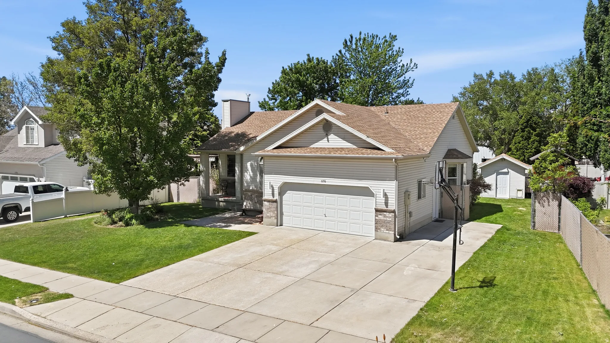 Single-story residence featuring a two-car garage and basketball hoop