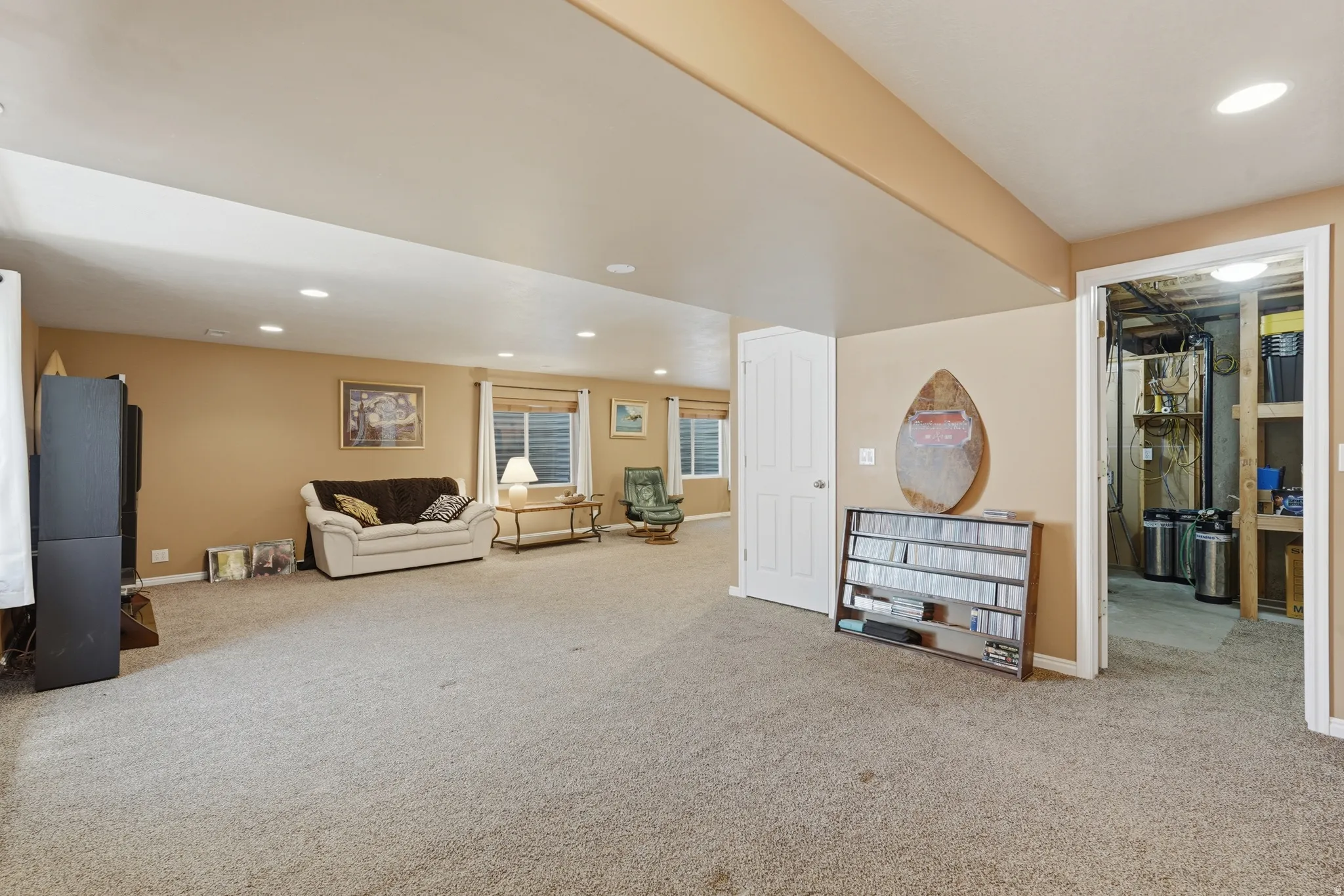 Spacious lower-level room showing access to utility/storage room