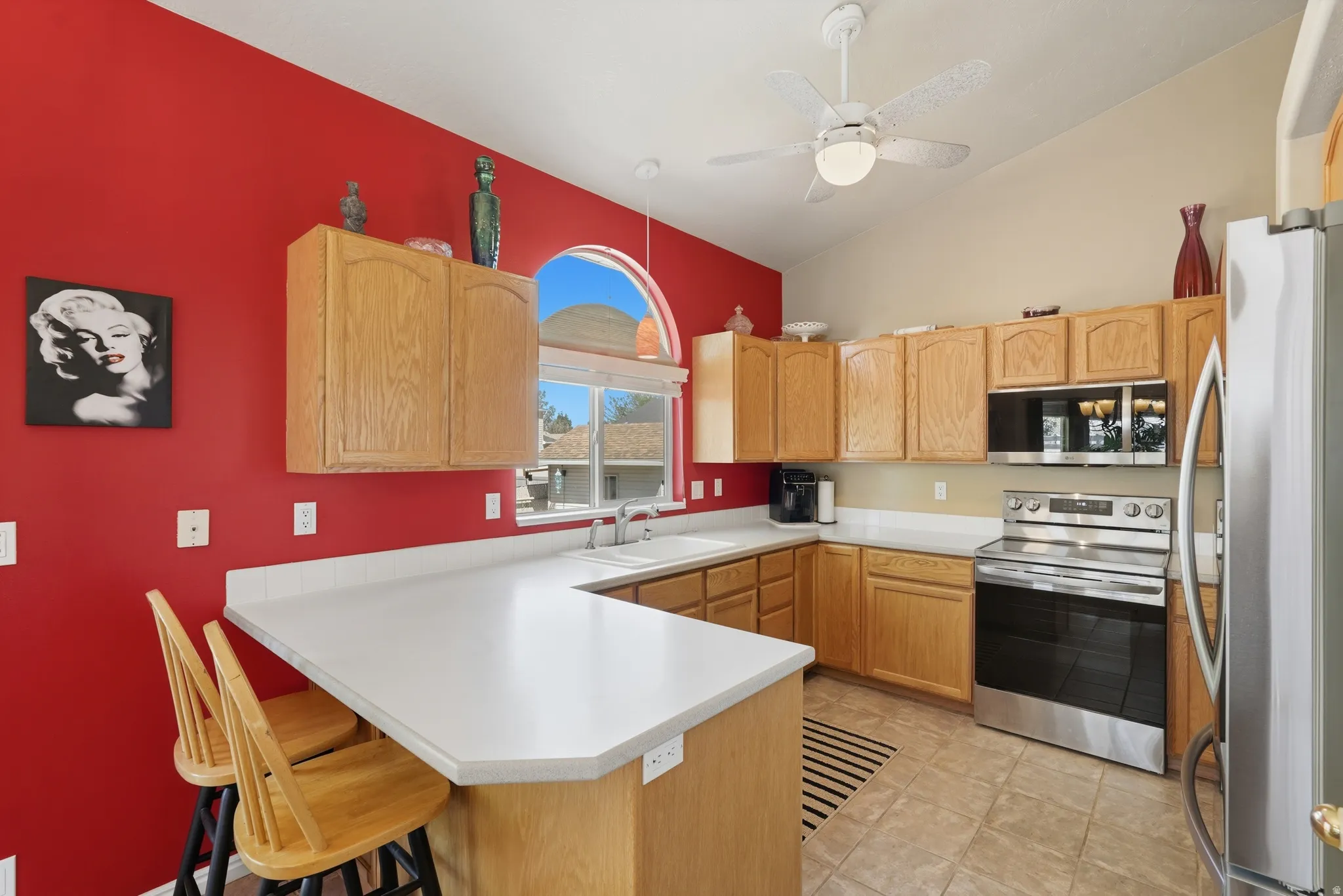 Kitchen featuring all new stainless steel appliances and a vaulted ceiling with a ceiling fan