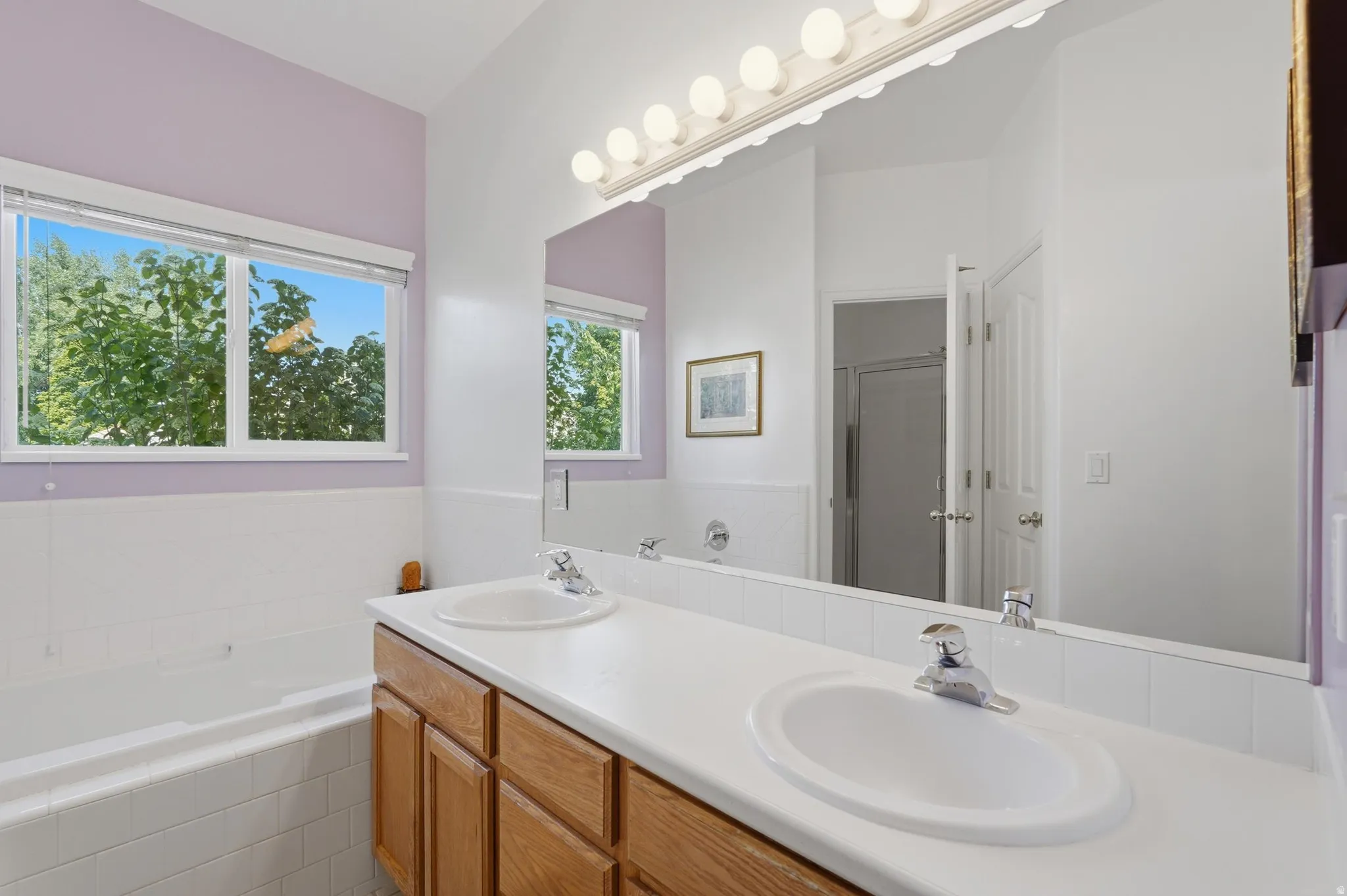 En suite bathroom featuring a dual sink vanity and soaking tub