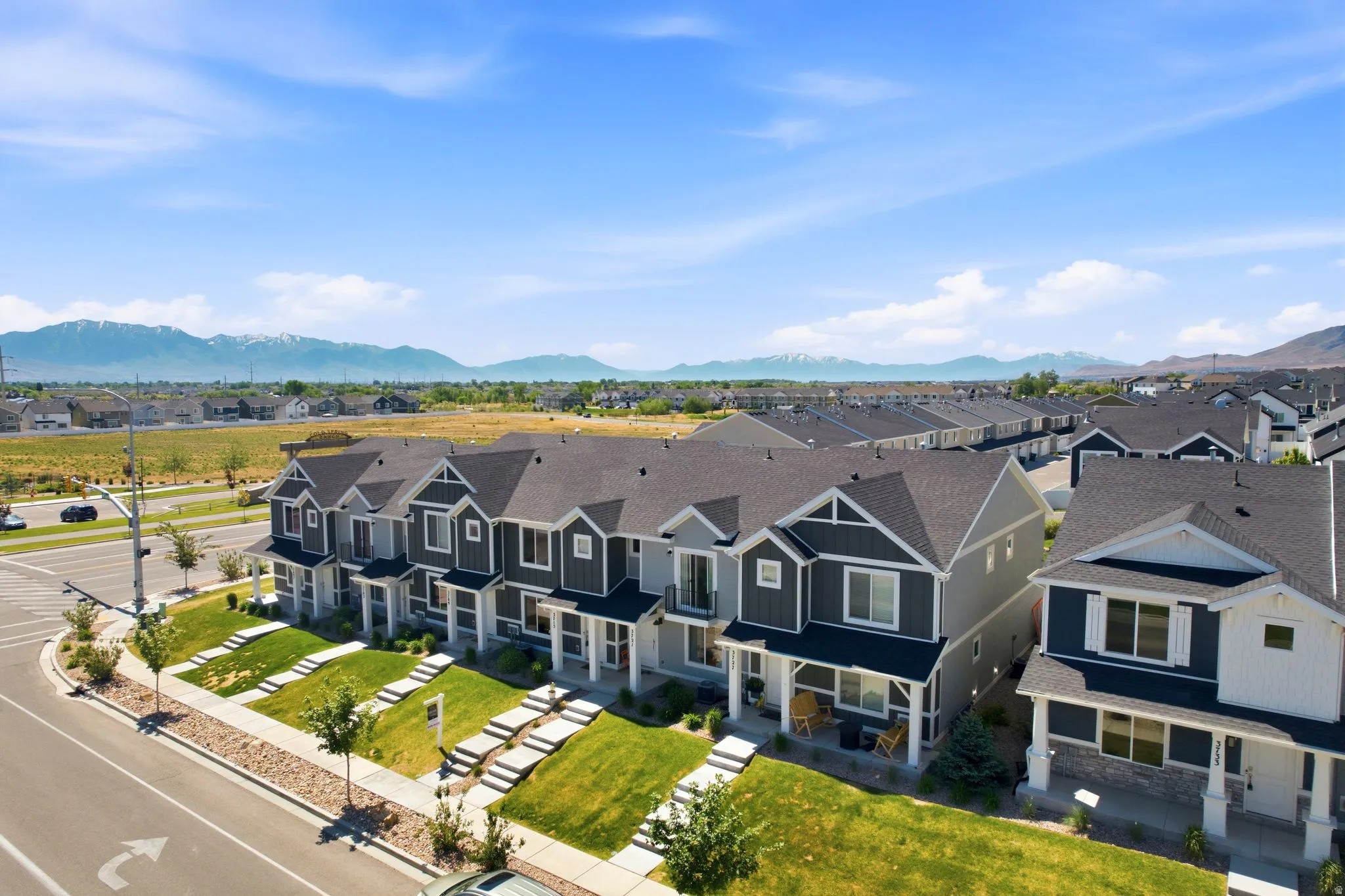 Row of modern townhomes with contrasting siding and stone facade accents