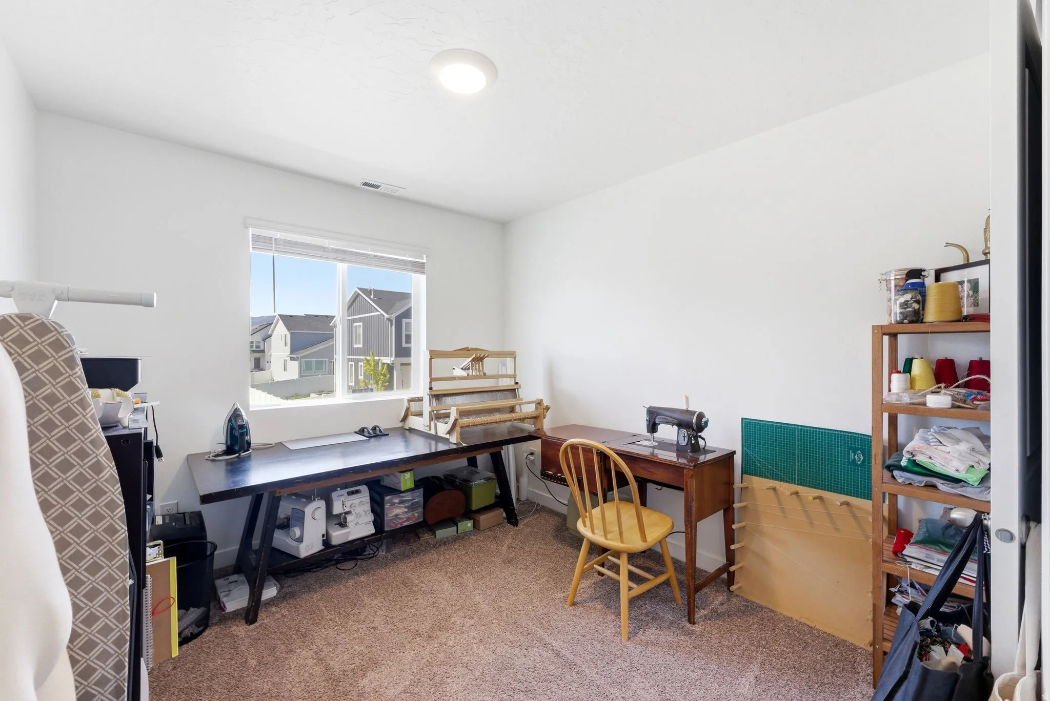 Carpeted room with a recessed ceiling light and a window featuring horizontal blinds