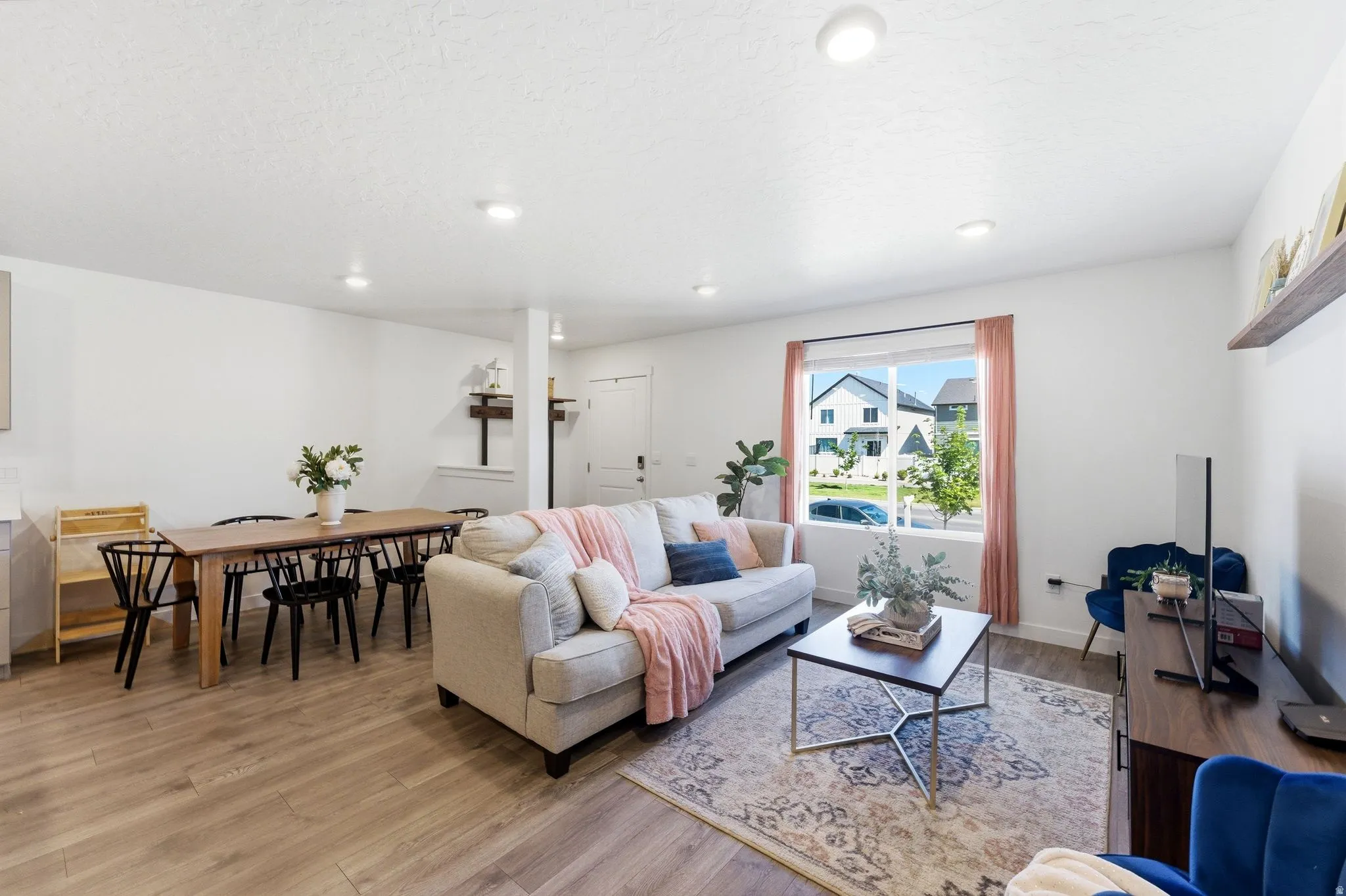 Bright living area with recessed lighting and wood-finish flooring