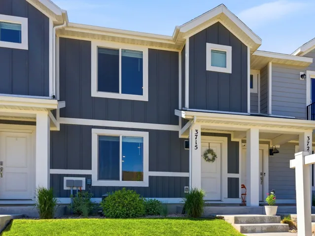 Modern townhome exterior featuring contemporary dark gray vertical siding with white trim