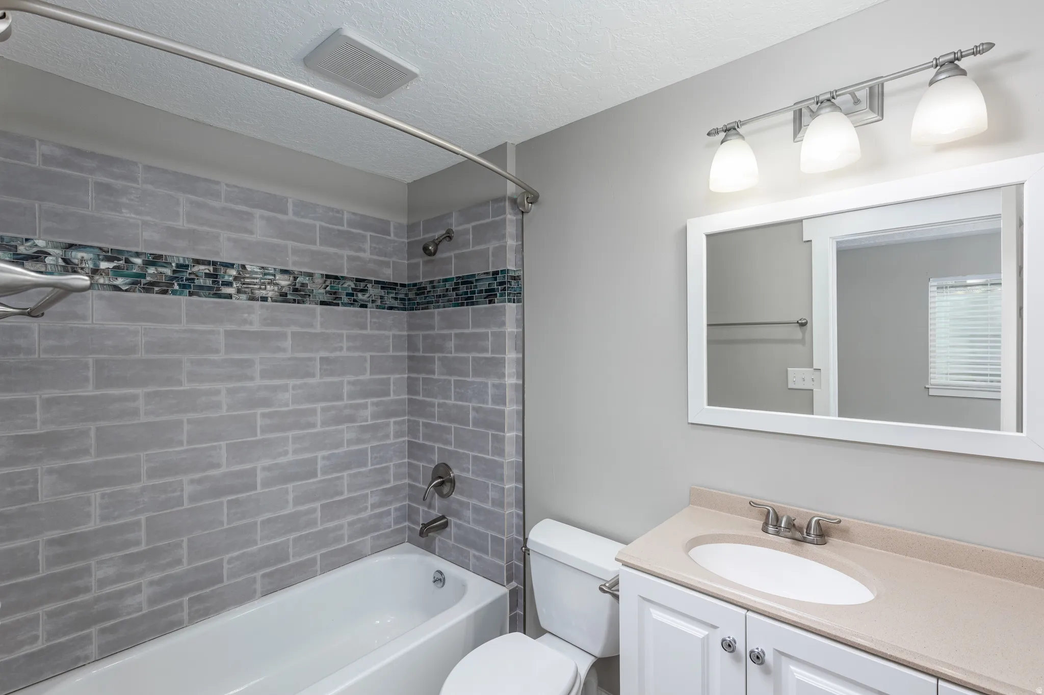 Bathroom featuring a white vanity with a light-toned countertop, an oval undermount sink, and brushed nickel fixtures