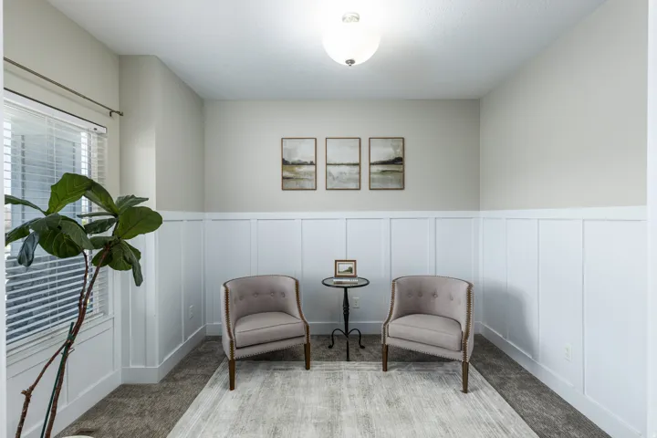 This room features wainscoting paneling, light-toned walls, a textured ceiling, and a ceiling-mounted light fixture