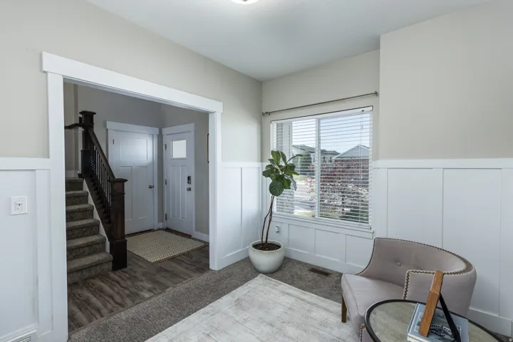 Entryway featuring wood-finish flooring and a carpeted staircase with a dark wood newel post and balusters