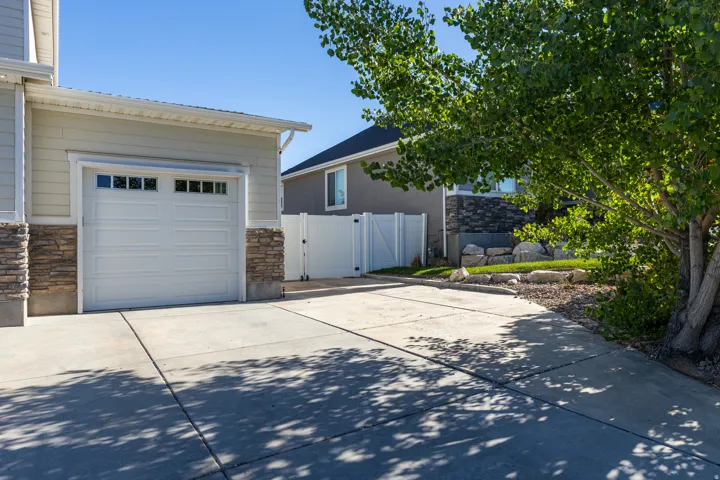 Concrete driveway leading to an attached garage with paneled door and upper windows