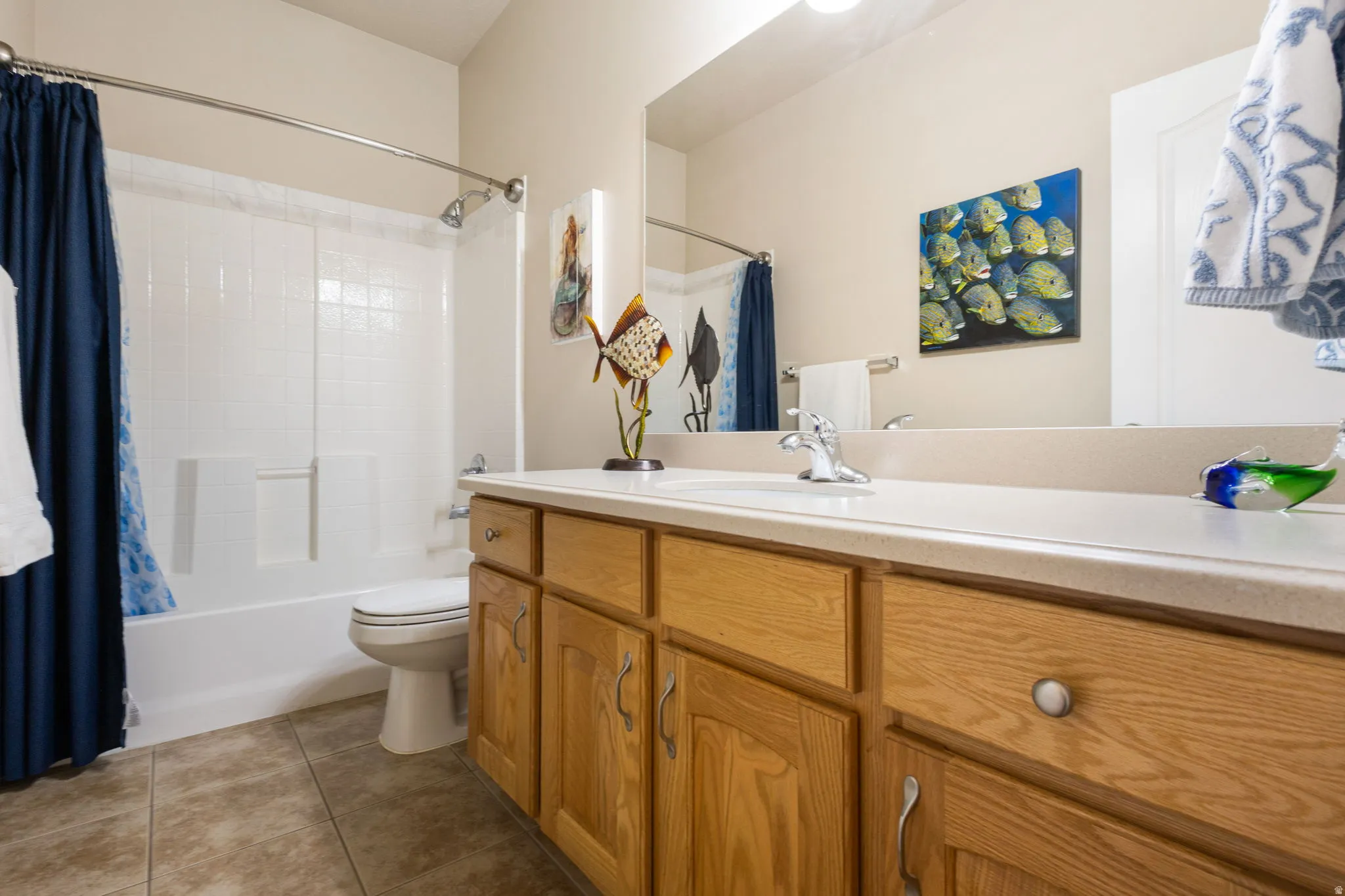 Full bathroom featuring a full vanity with wood-finish cabinetry, integrated sink, and laminate countertop