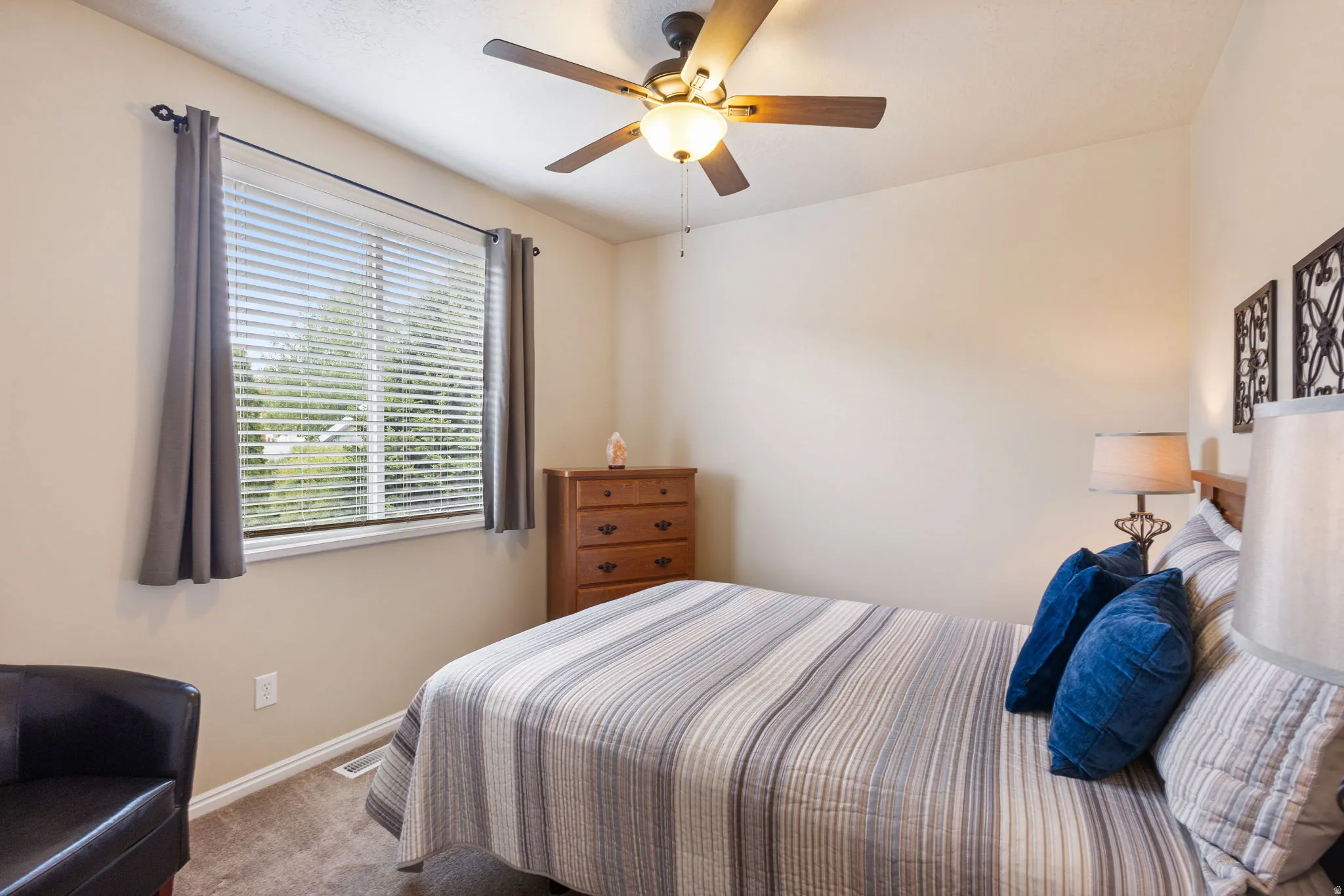 Carpeted room featuring a ceiling fan with integrated lighting, a window with blinds, and neutral wall tones