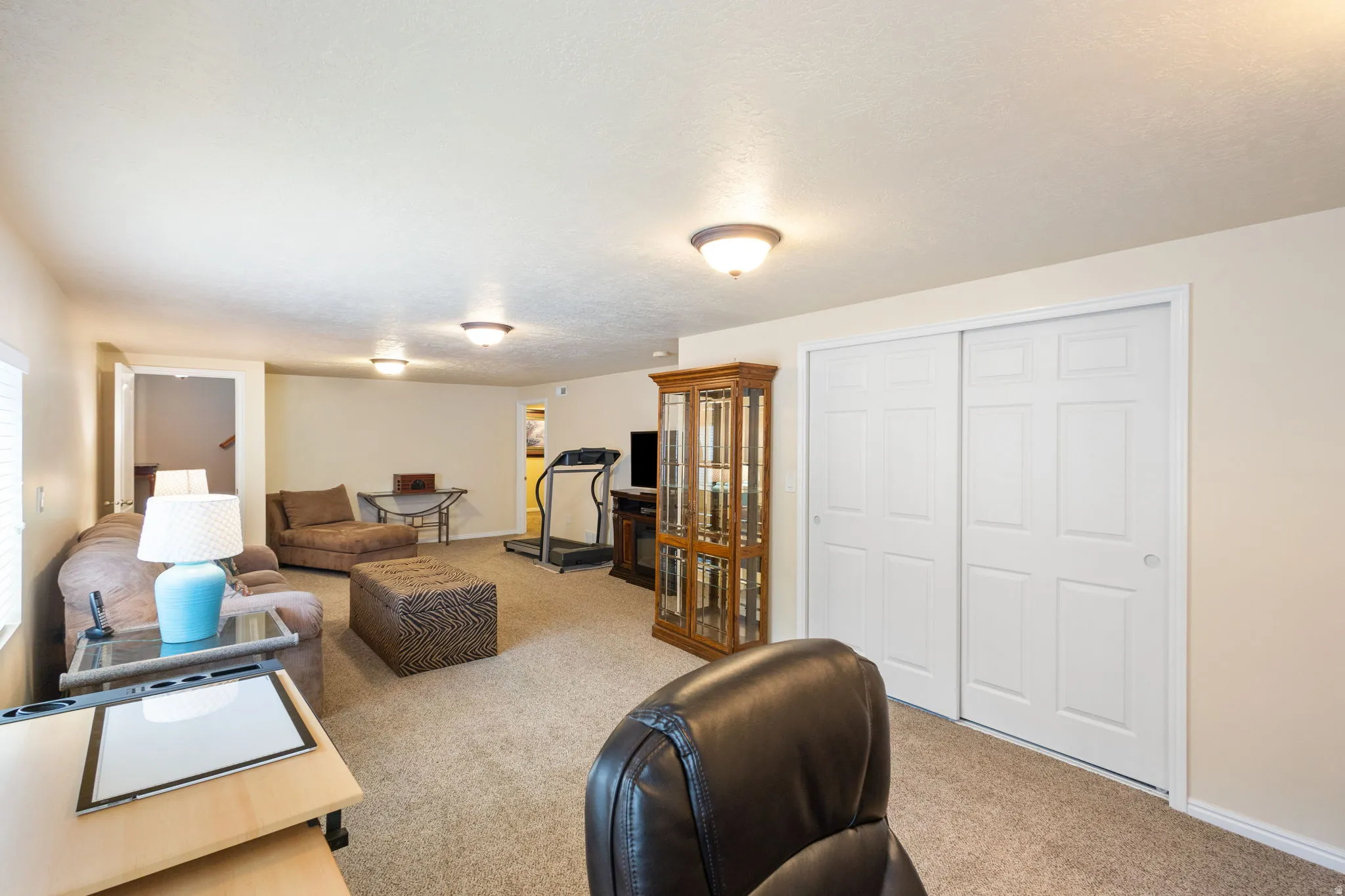 Carpeted room with recessed lighting and a white bi-fold closet door