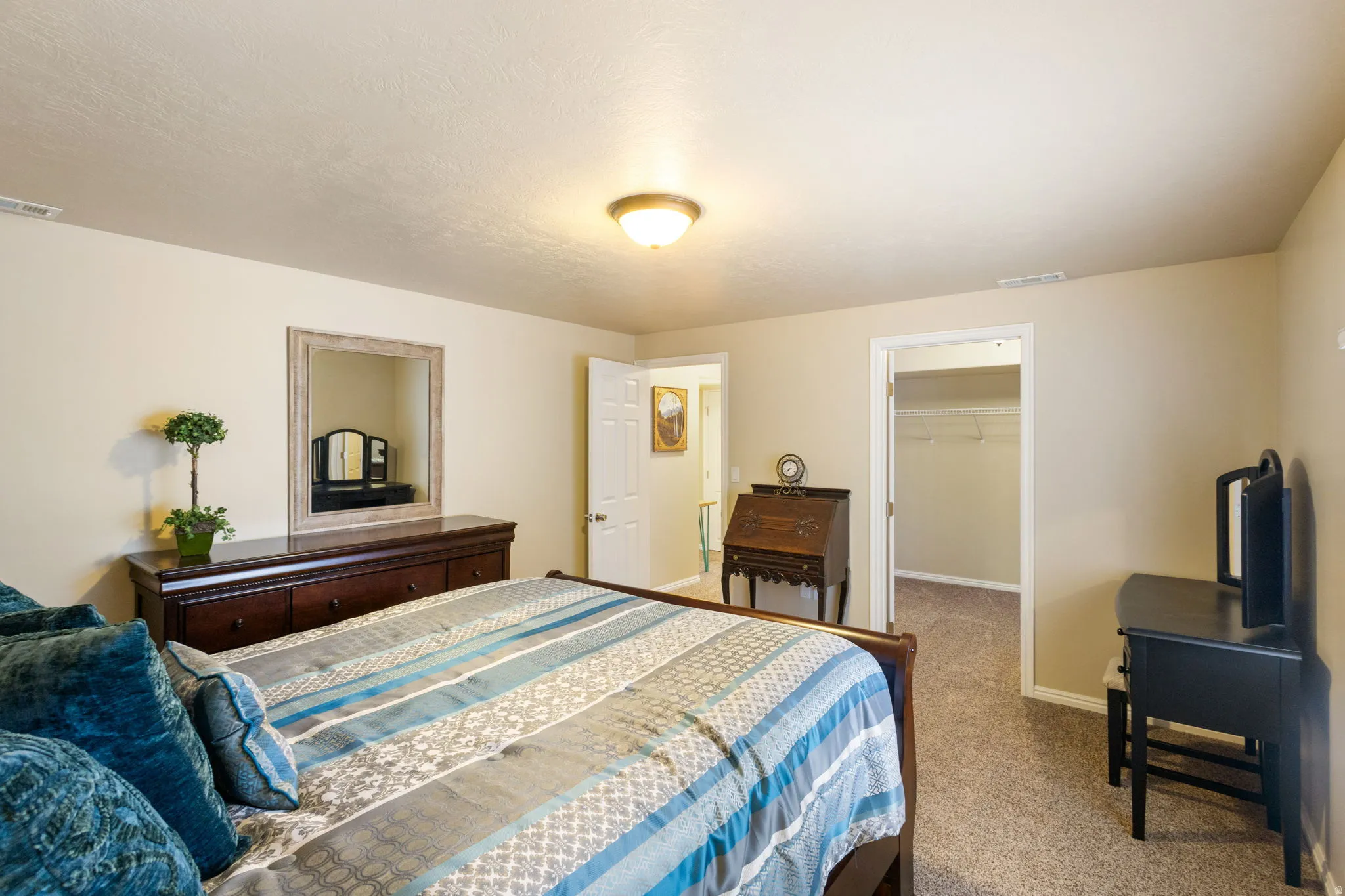 Carpeted room featuring neutral-toned walls, a standard ceiling light fixture, and a built-in closet with carpeted flooring