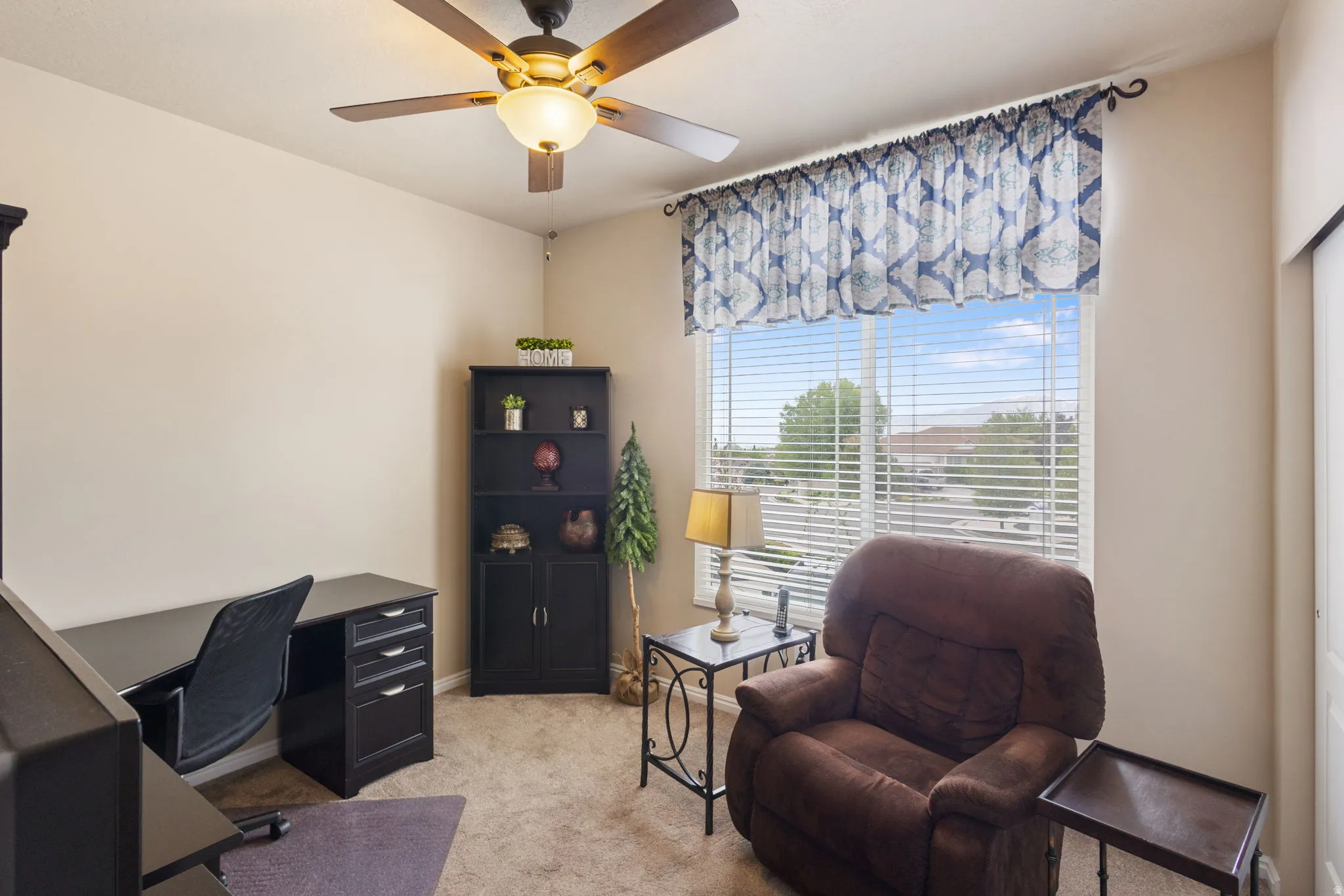 Room with neutral-toned walls, a ceiling fan with integrated lighting, and carpet flooring
