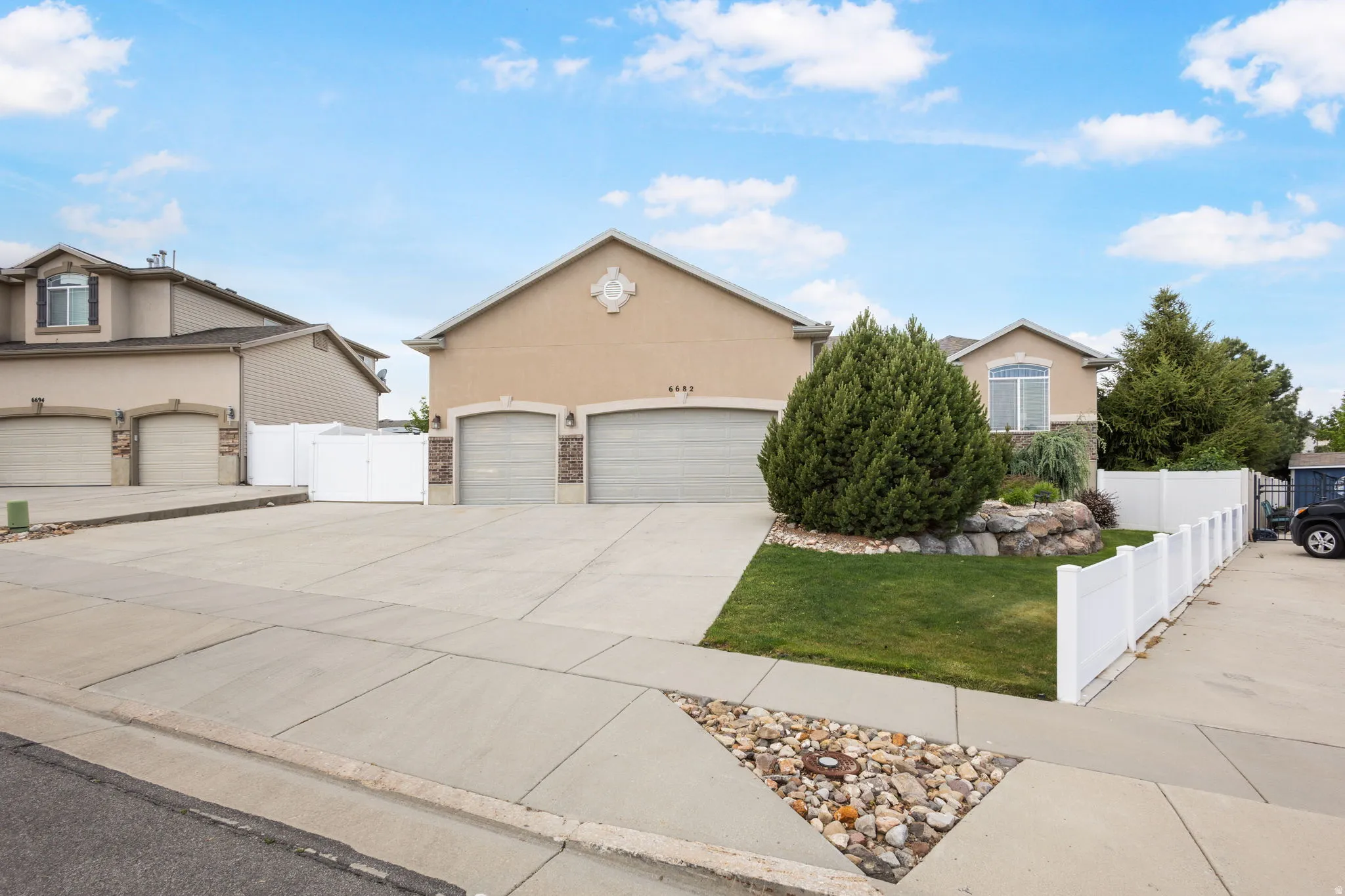 Stucco exterior featuring a two-car garage with arched entries and stone accents