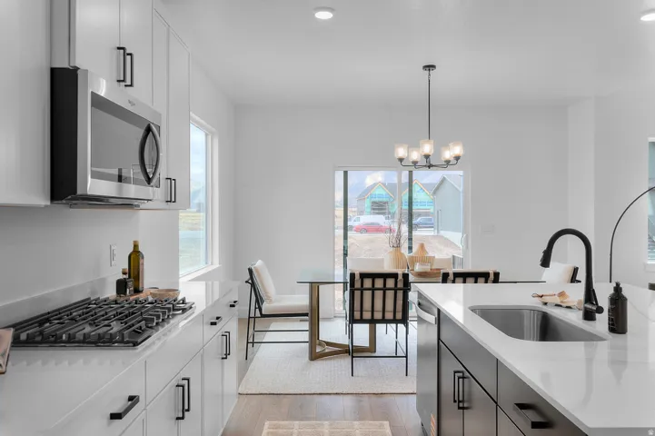 Modern kitchen featuring white cabinetry, stainless steel microwave, and a built-in gas range