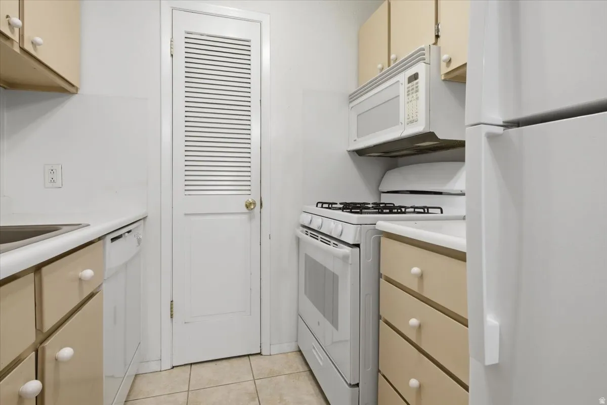 Kitchen featuring a white refrigerator, gas range with an overhead microwave, and a dishwasher