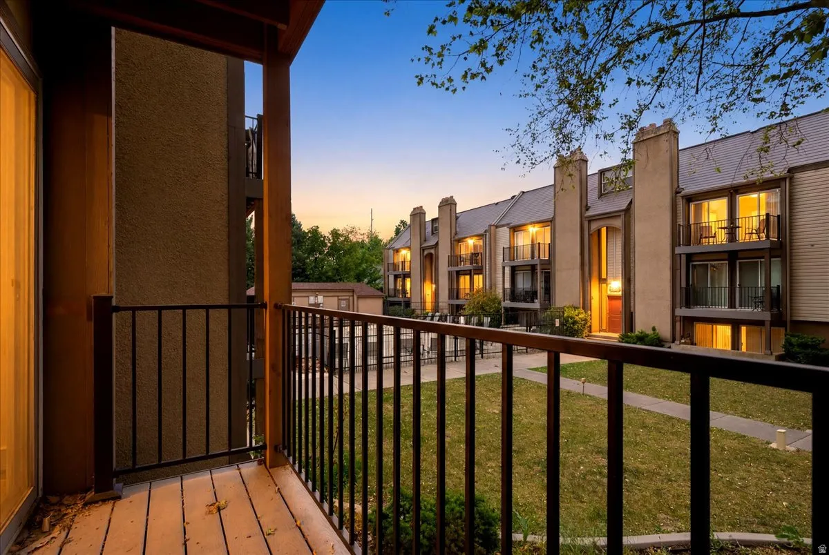 Private balcony with wood-finish flooring and black metal railings