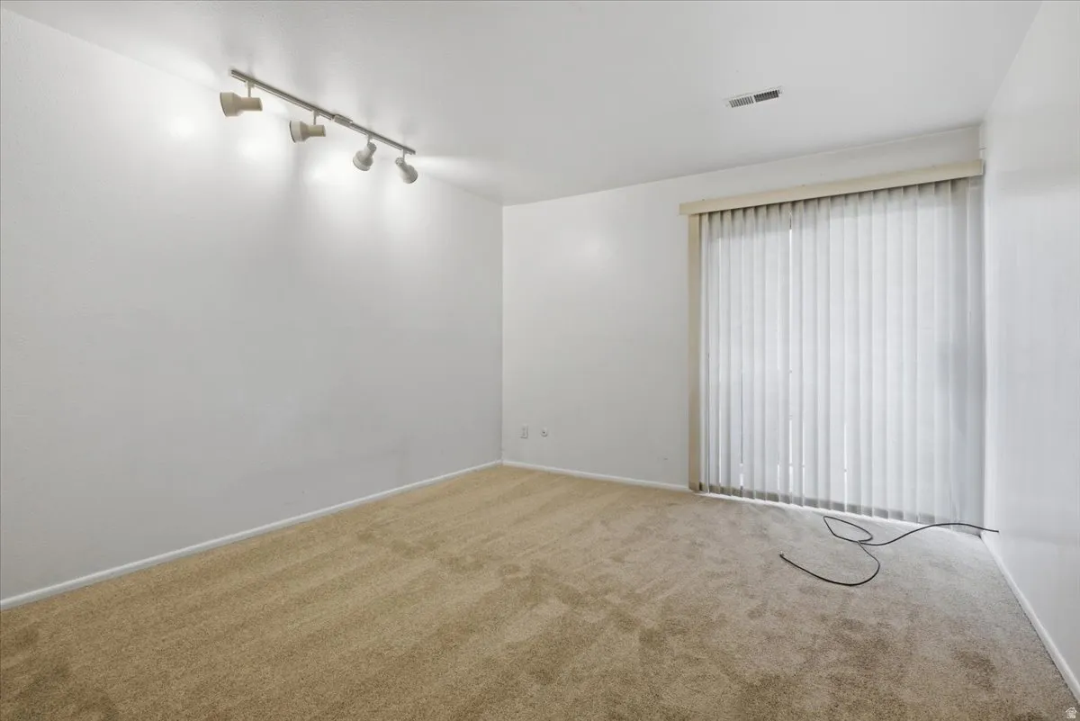 Neutral carpet flooring with white baseboards and walls