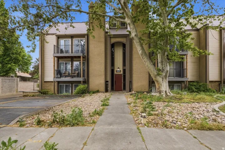 Multi-story exterior with a central entryway featuring a red door