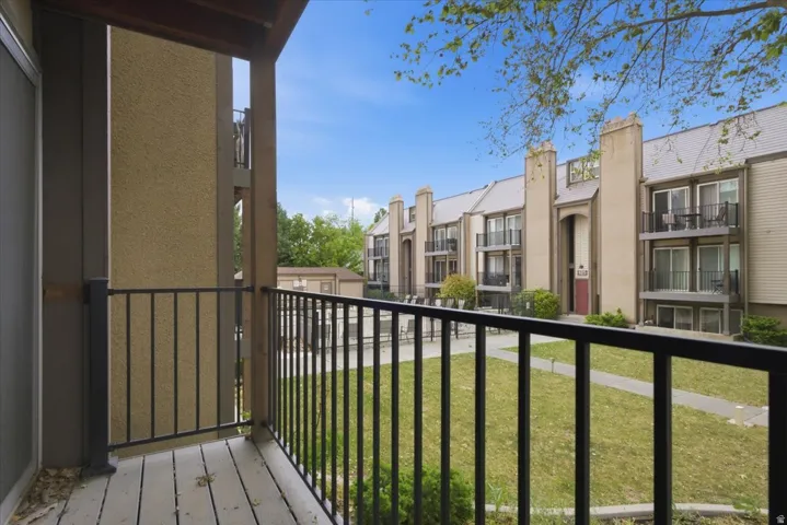 Private balcony with wood-finish flooring and black metal railing