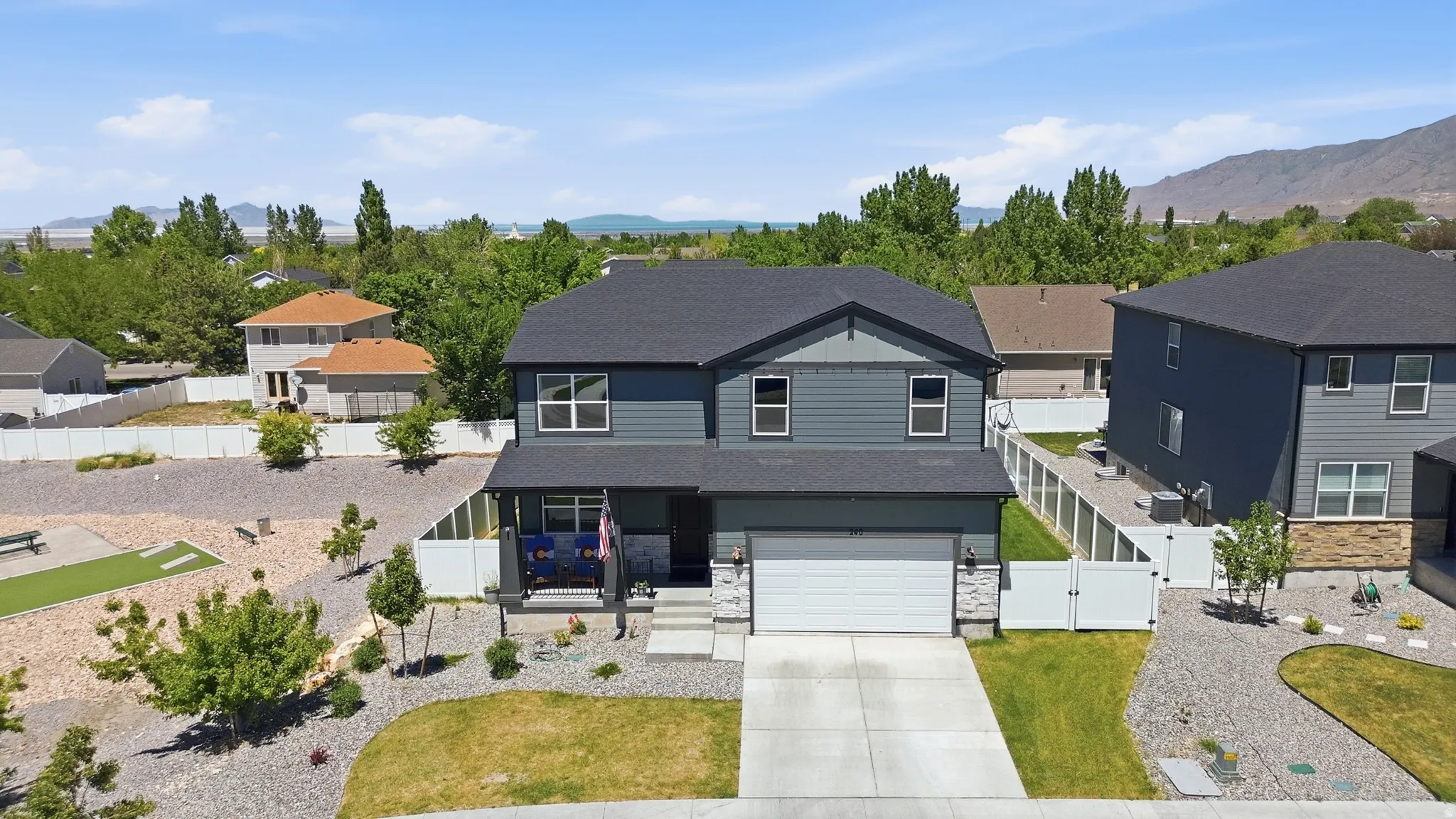 Two-story residence featuring a dark gray siding exterior and a light gray stone facade