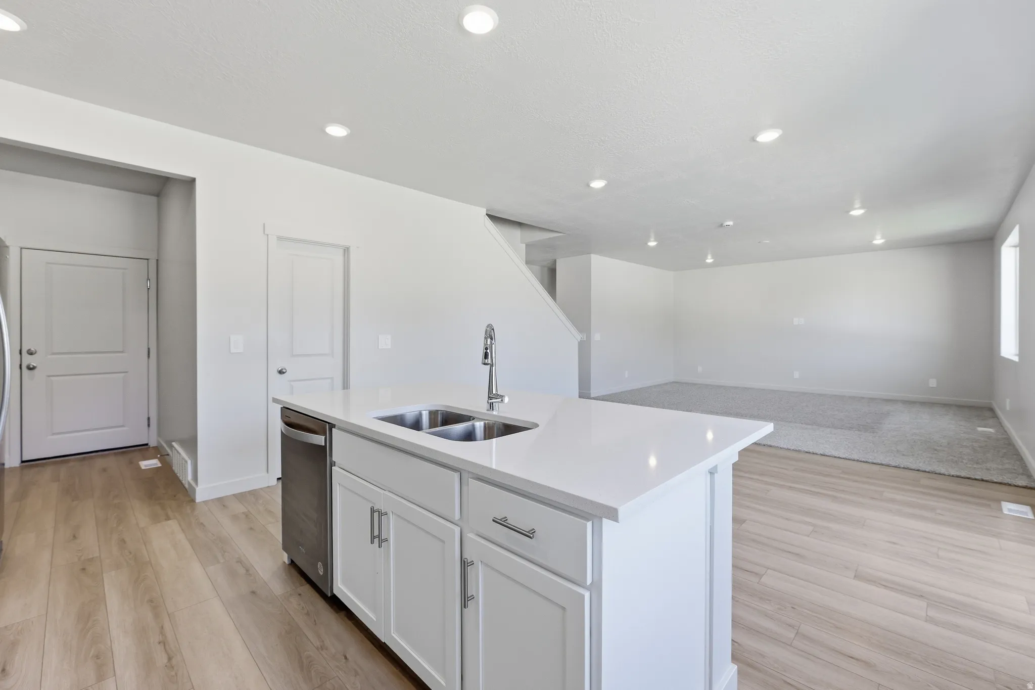 Kitchen island featuring a double basin sink and a stainless steel faucet