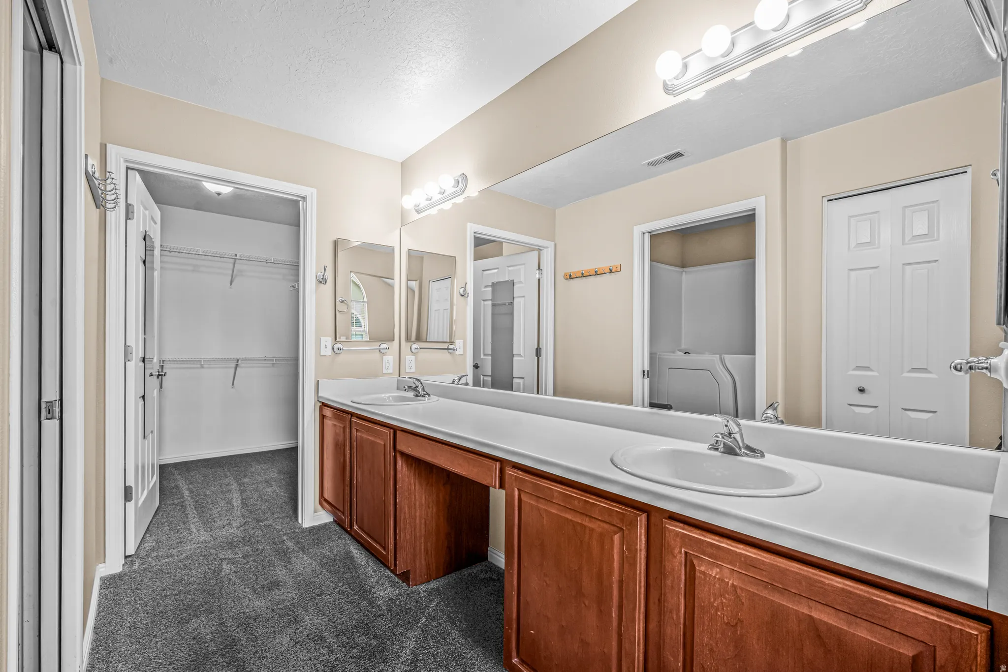 Dual sink vanity with wood-finish cabinetry and ample countertop space