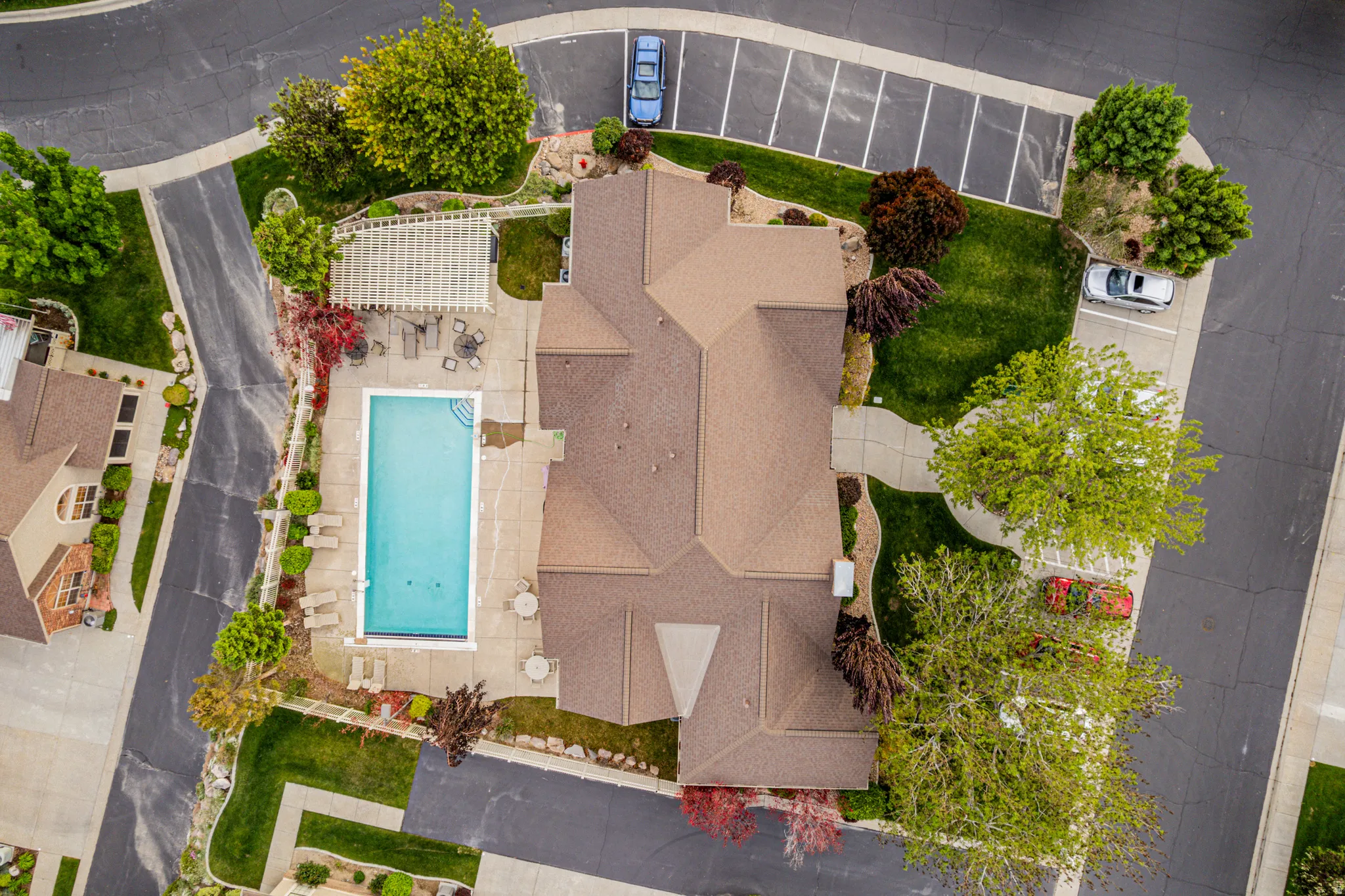 Community clubhouse with rectangular swimming pool with an adjacent pergola-covered patio area