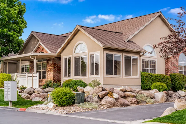 Stucco and brick exterior featuring a multi-gable roofline and arched window details