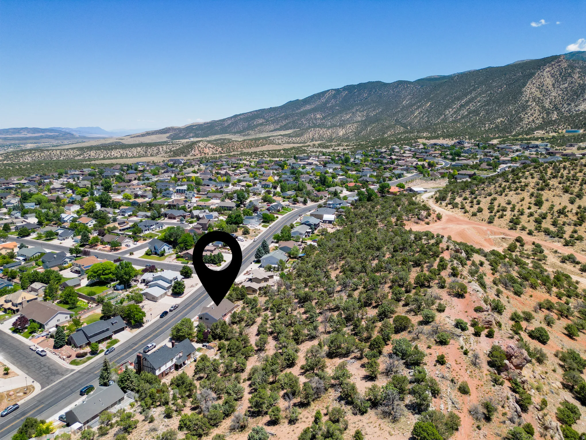 Expansive aerial perspective showcasing a residential neighborhood against a mountainous backdrop