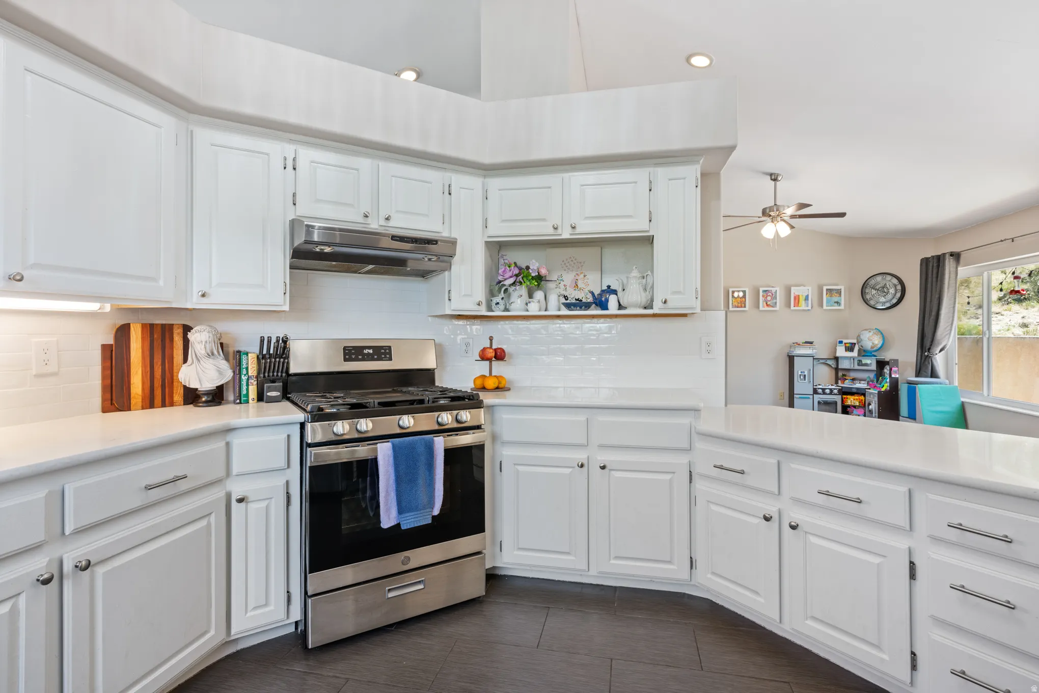 Modern kitchen featuring white cabinetry, a stainless steel range with matching hood, and white subway tile backsplash
