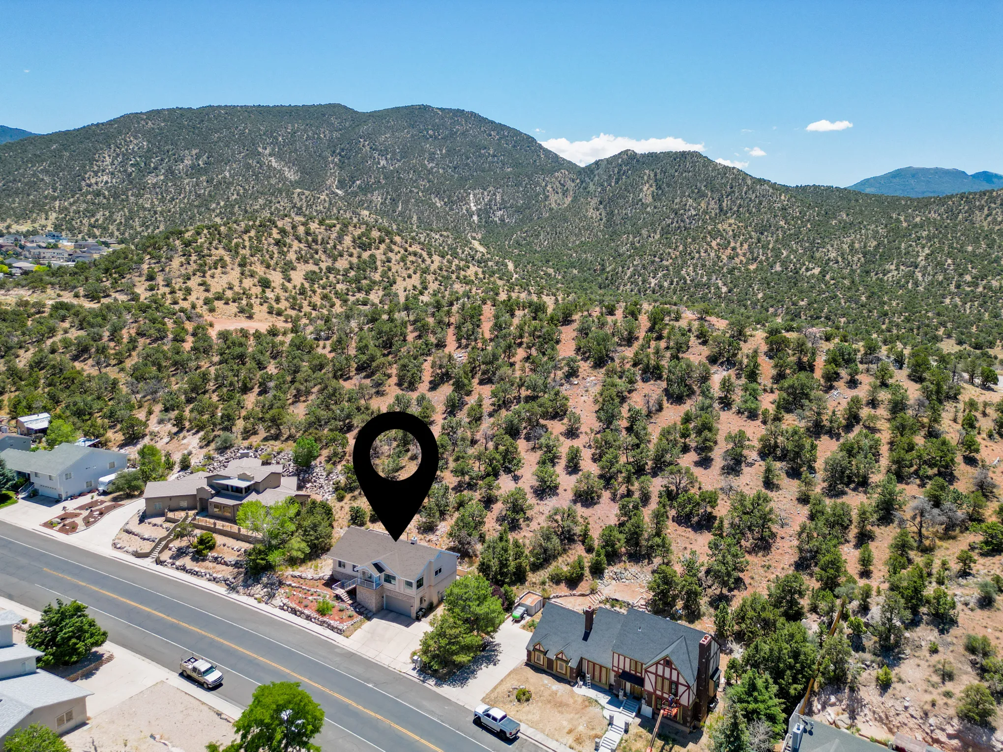 Hillside residential area with extensive natural landscaping and distant mountain ranges